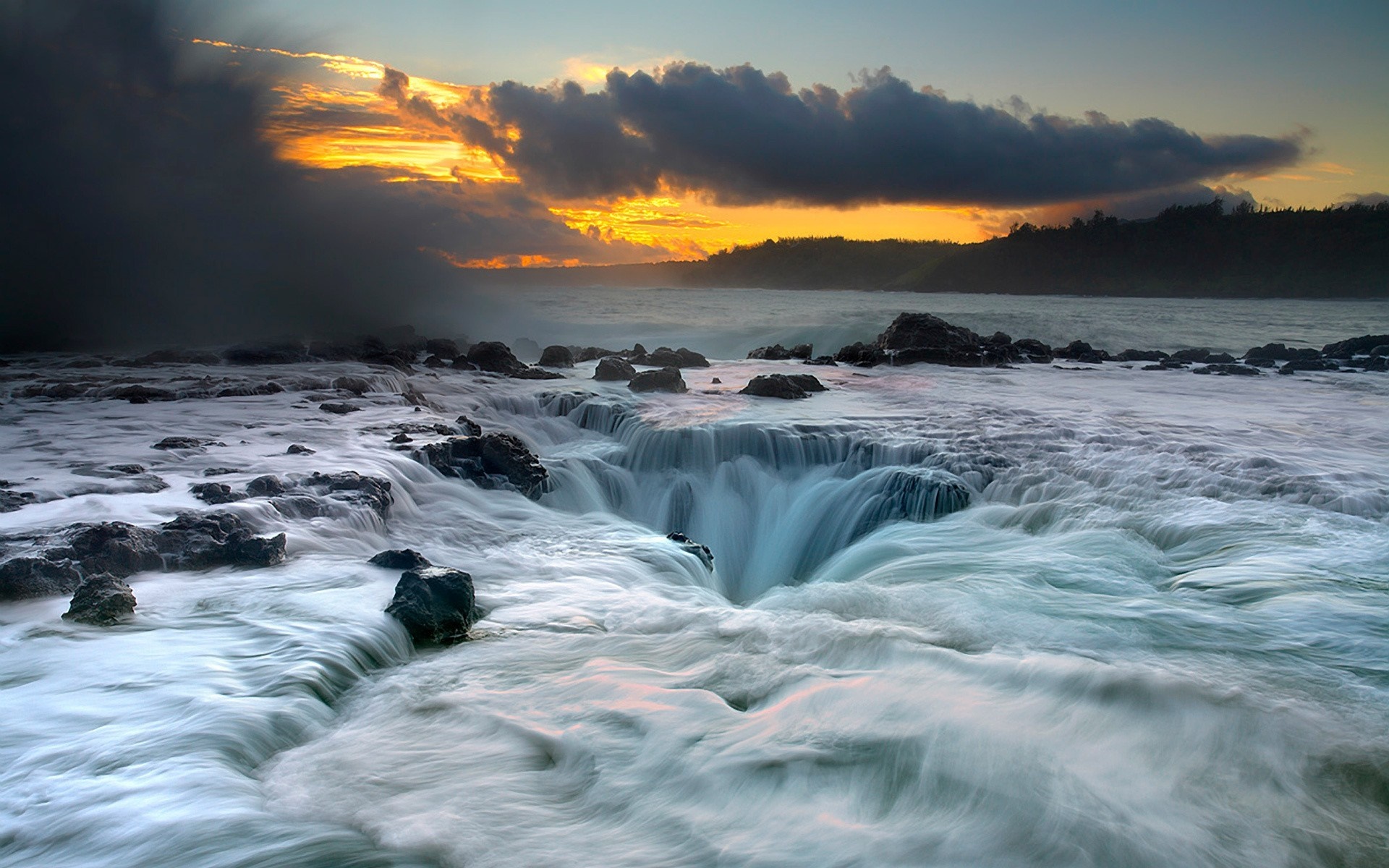 Ocean waves crashing over rocks at sunset HD Wallpaper