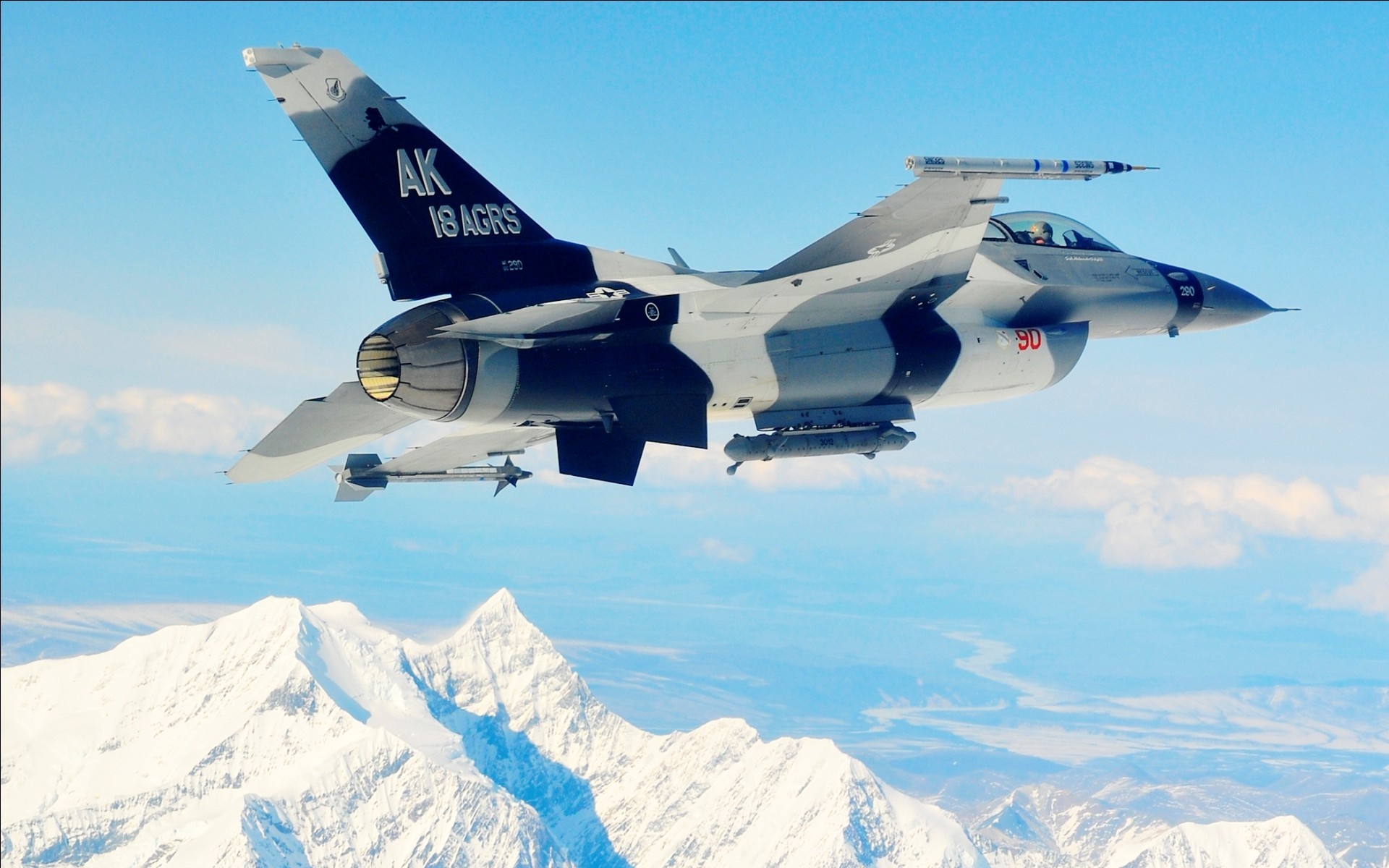F-16 Fighting Falcon flying over snow-capped mountains HD Wallpaper