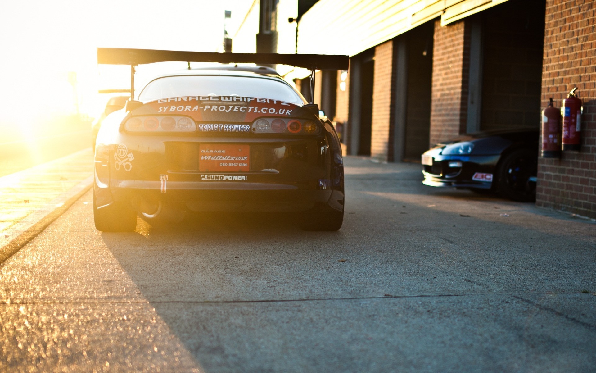 Toyota Supra with large rear spoiler at sunset HD Wallpaper
