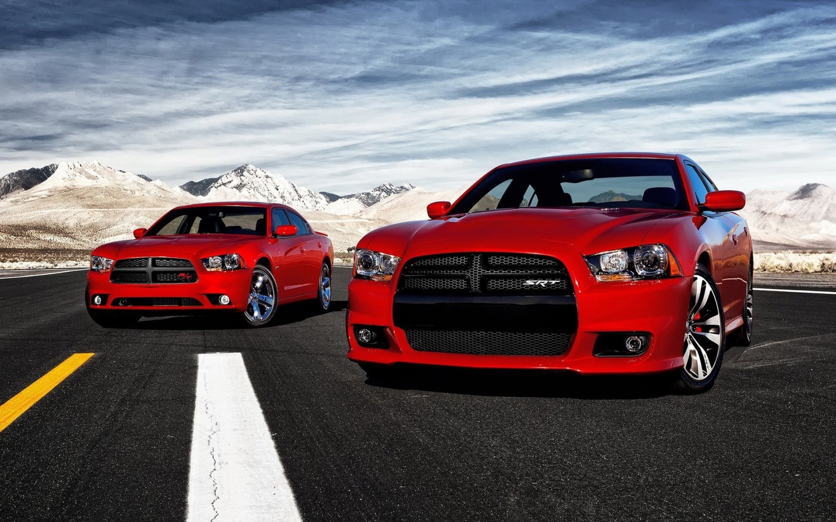 Two red Dodge Chargers on a road with mountains HD Wallpaper
