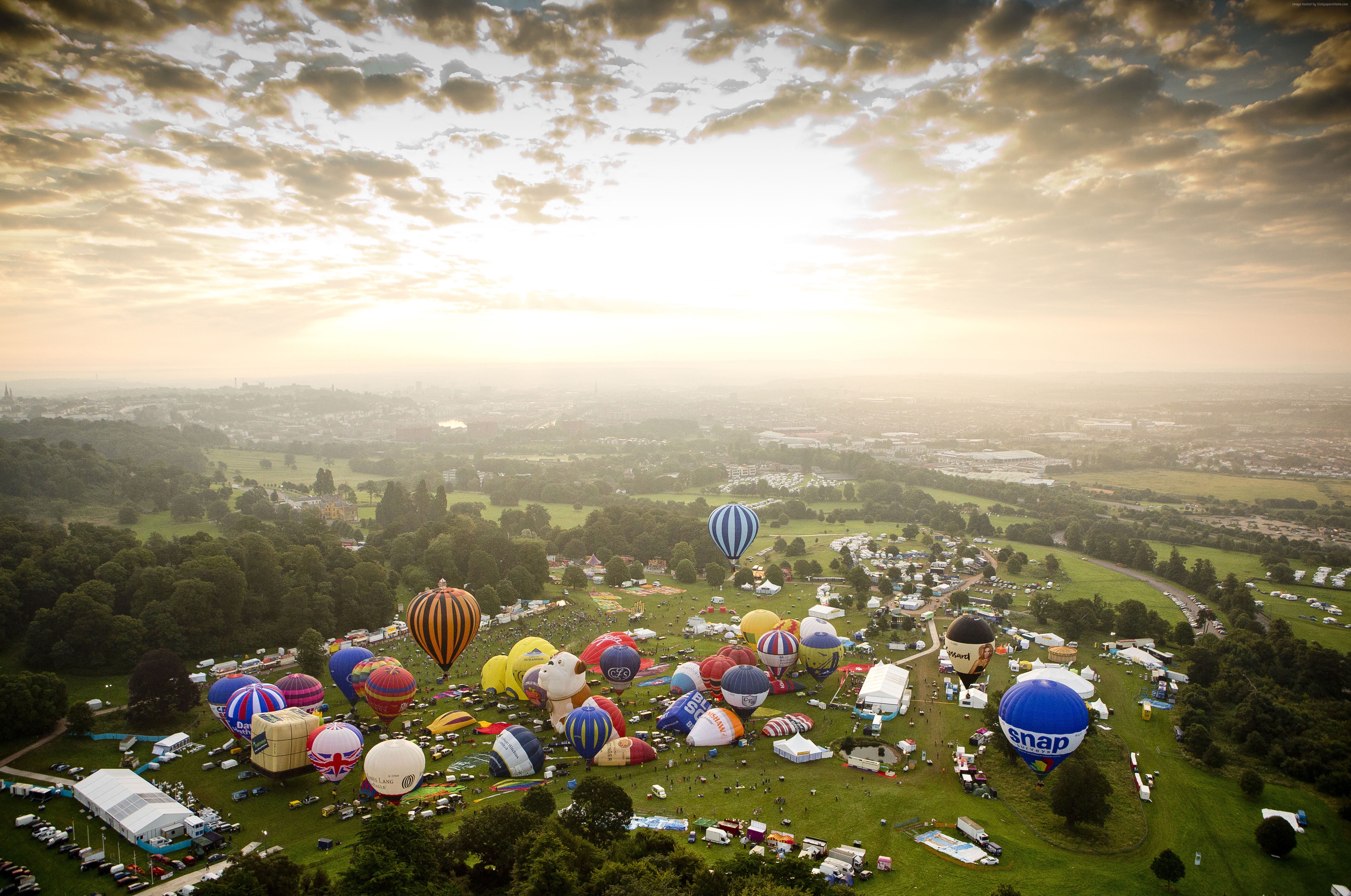 Hot air balloons at an outdoor event with a city in the background HD Wallpaper