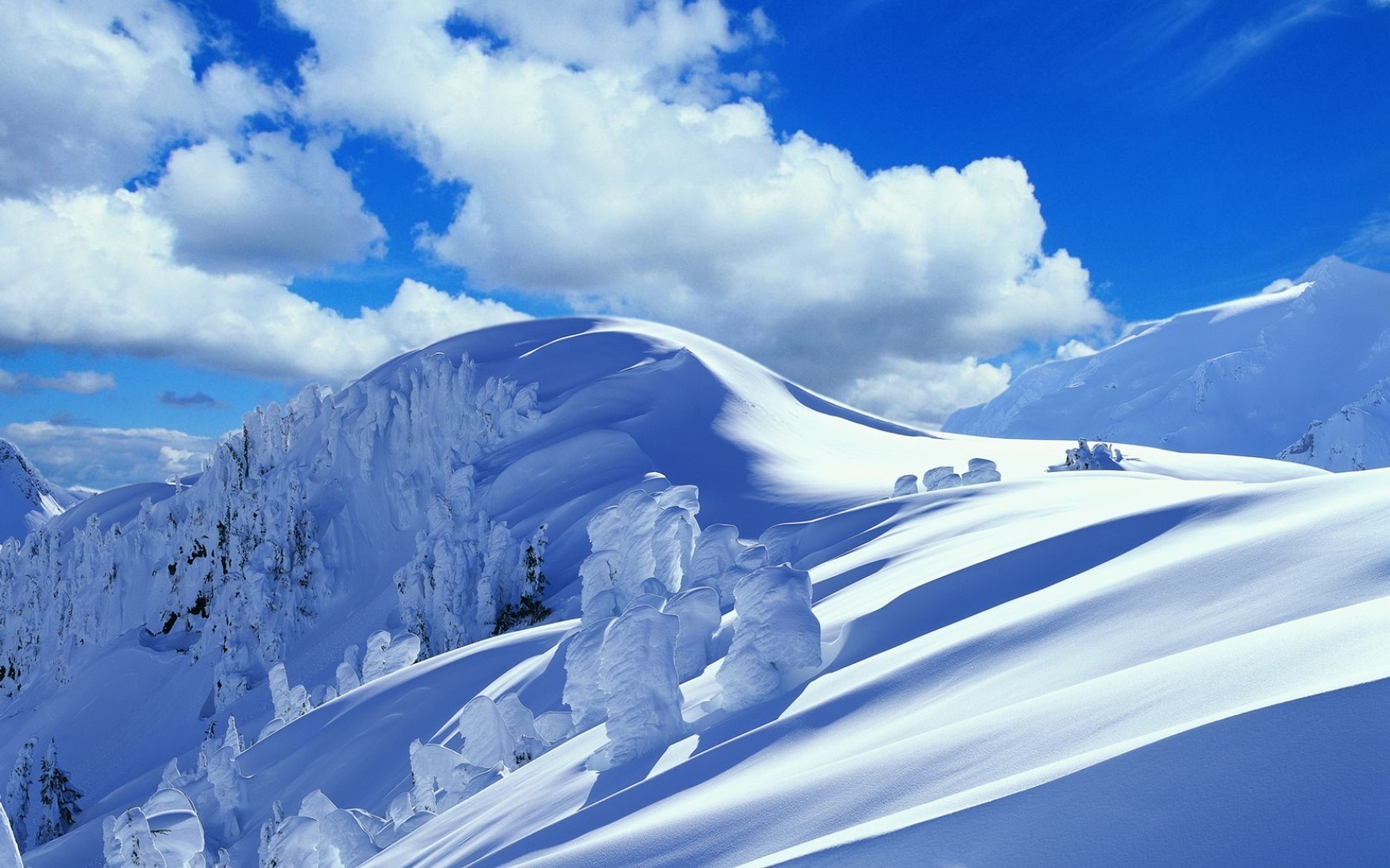 Snowy mountains under a blue sky with clouds HD Wallpaper