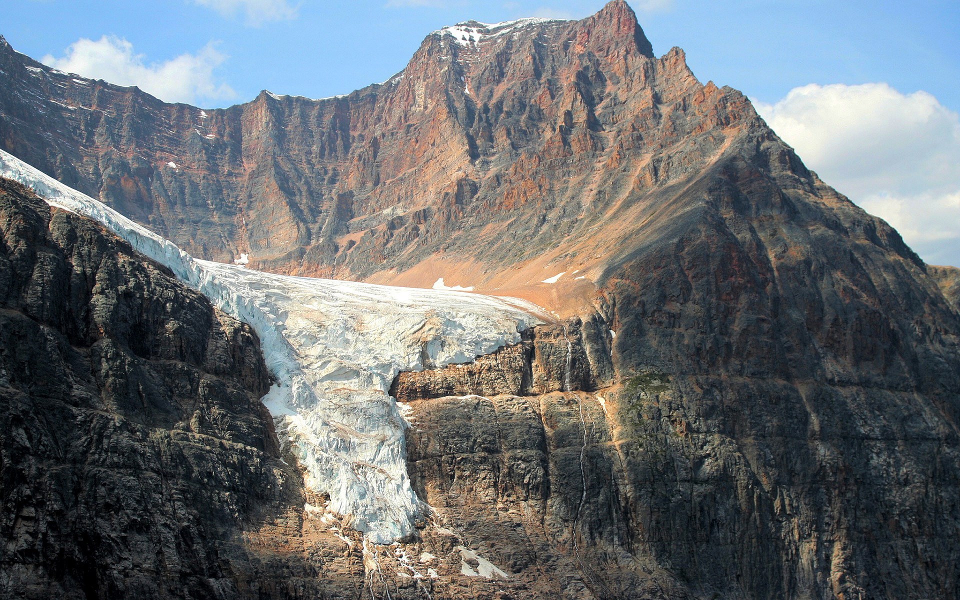 Glacier on a rocky mountain under a blue sky HD Wallpaper