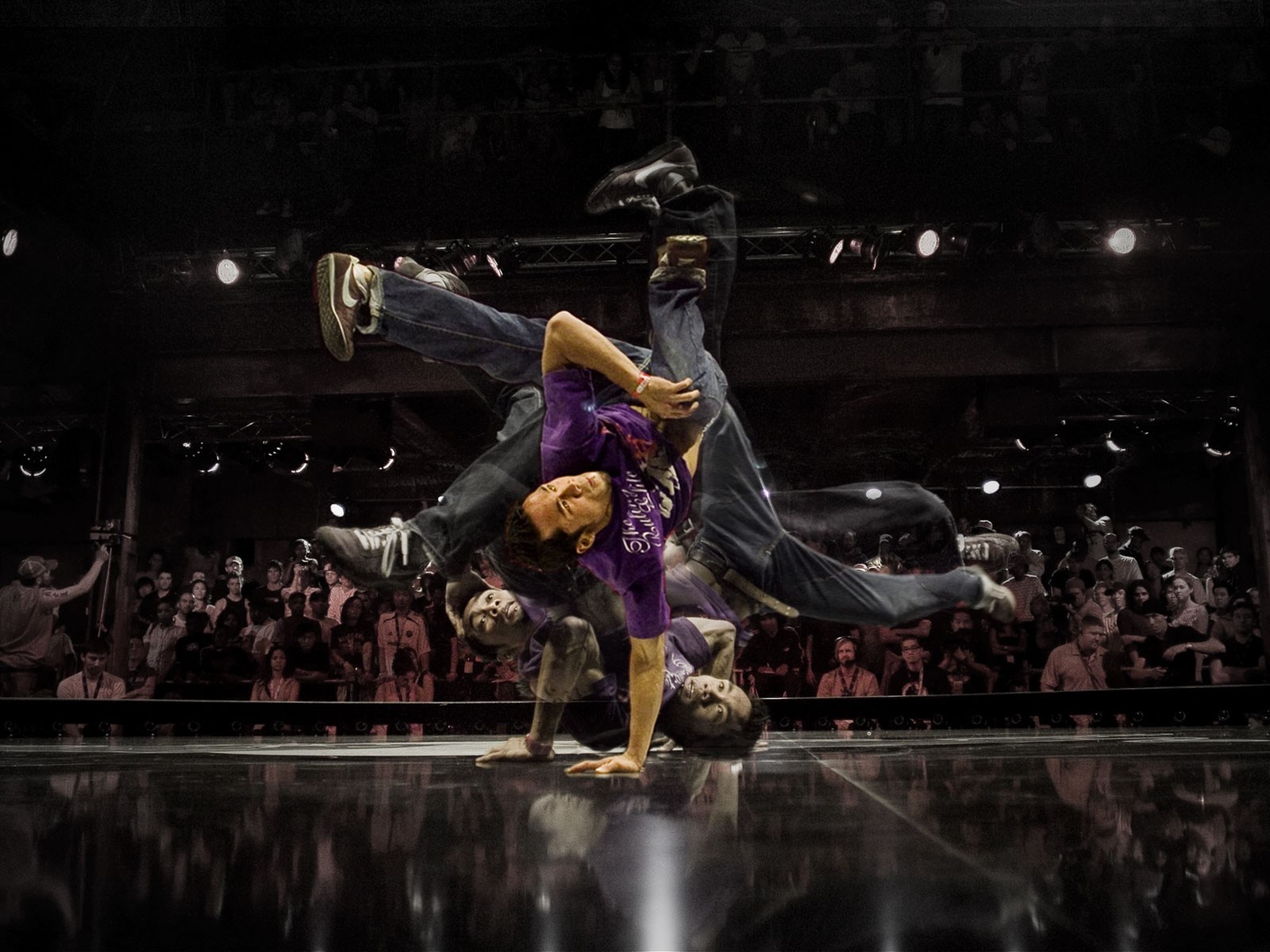 Breakdancer performing on stage with audience HD Wallpaper