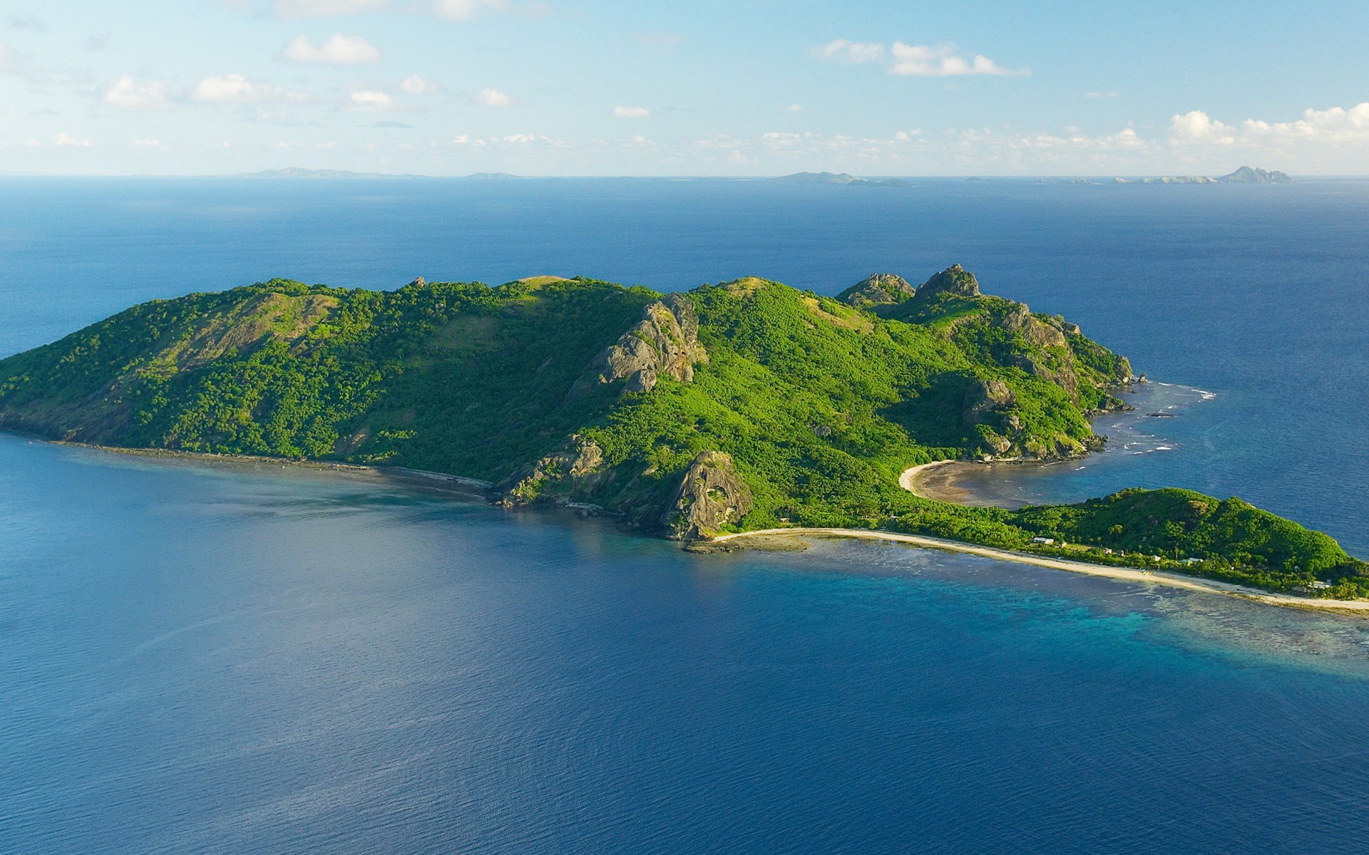 Island with green hills and blue ocean HD Wallpaper