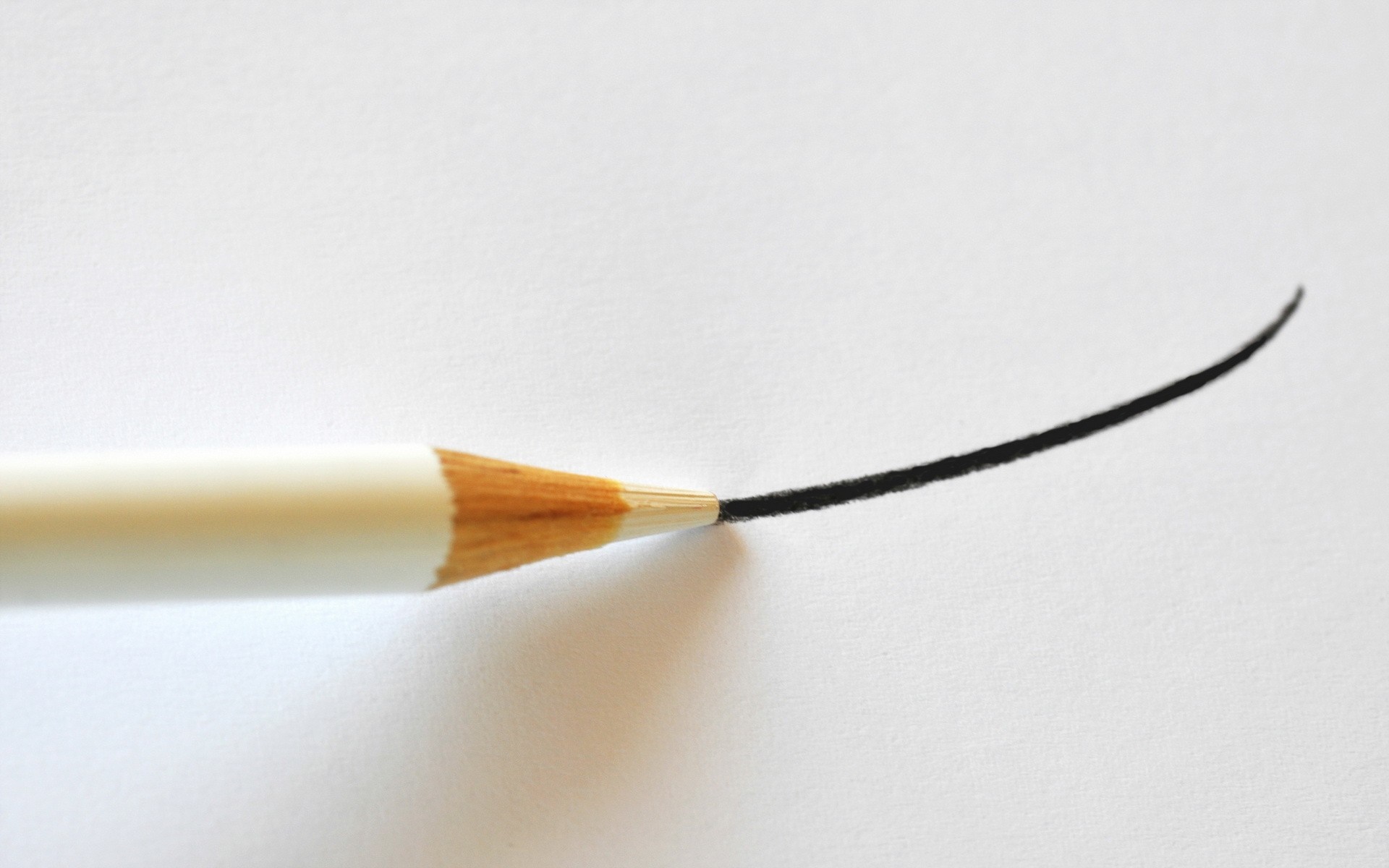 White pencil drawing a curved black line on white paper HD Wallpaper