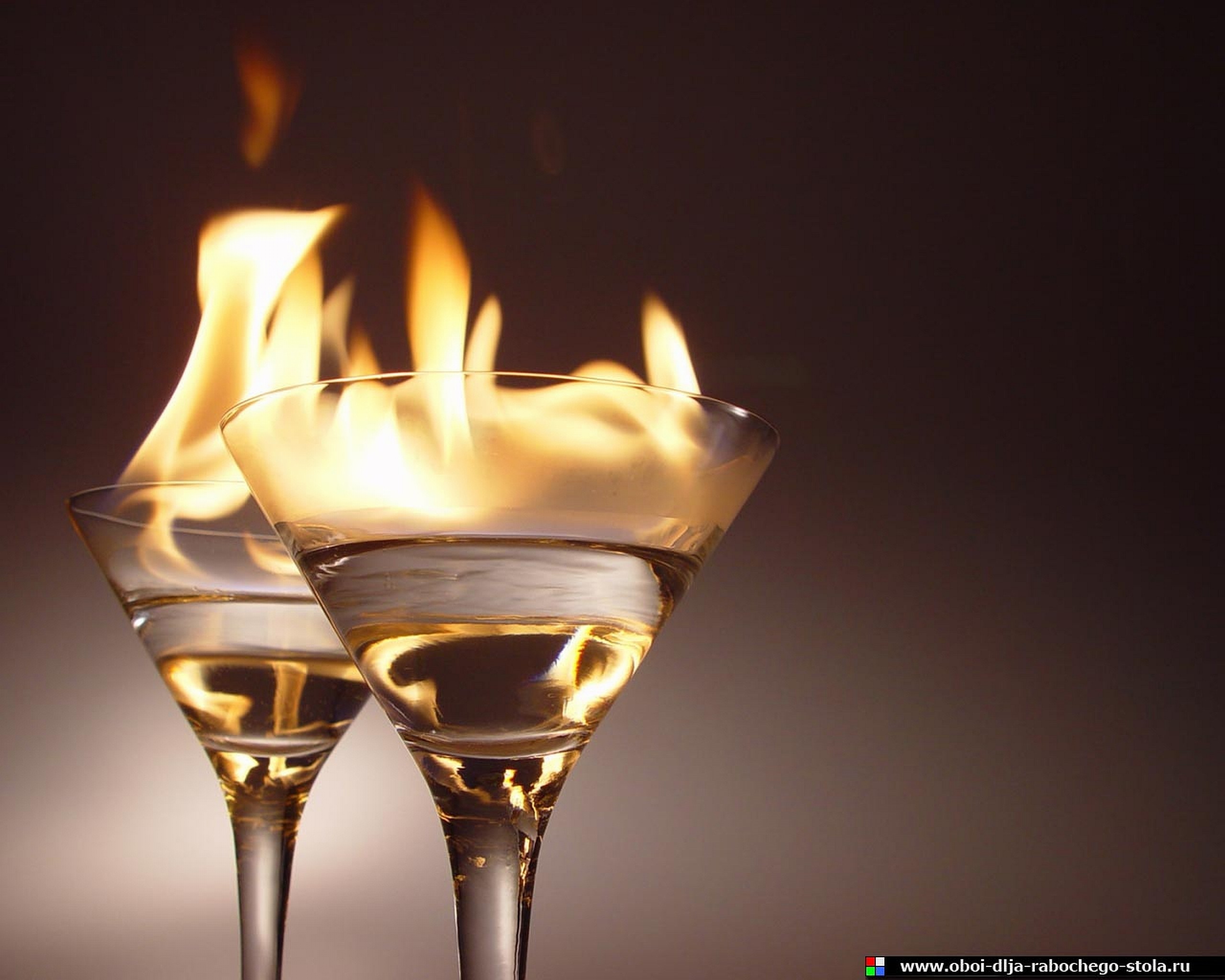 Two flaming cocktails in martini glasses HD Wallpaper