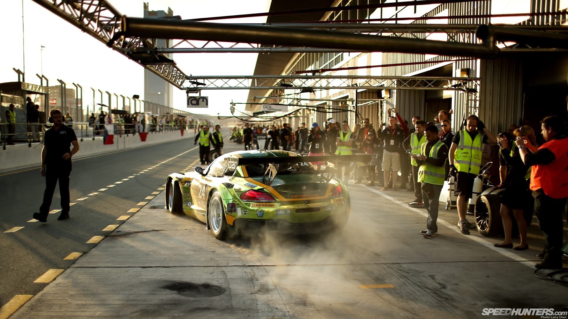 Race car in pit lane with crew HD Wallpaper