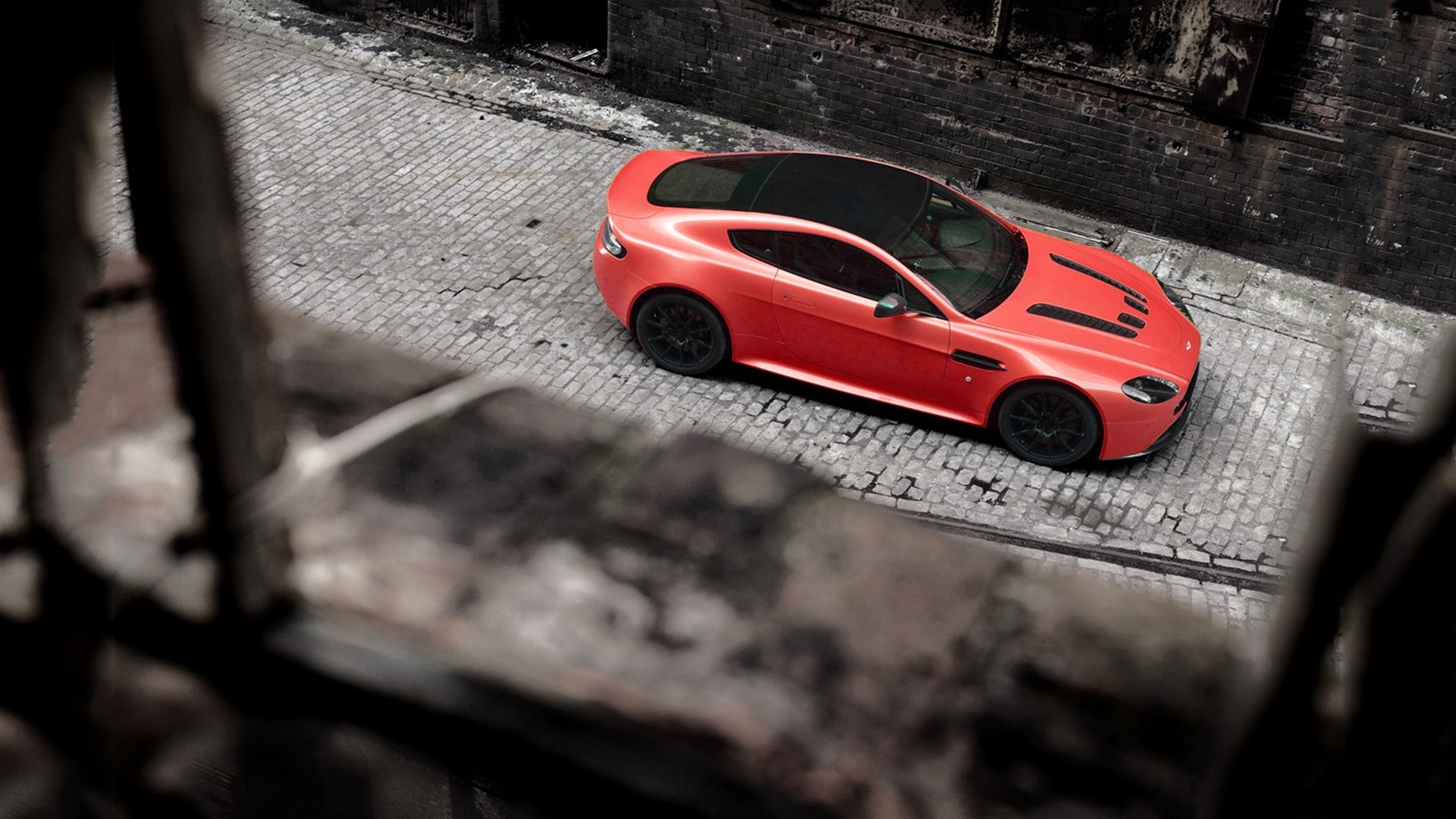 Red Aston Martin Vantage parked on cobblestone street HD Wallpaper