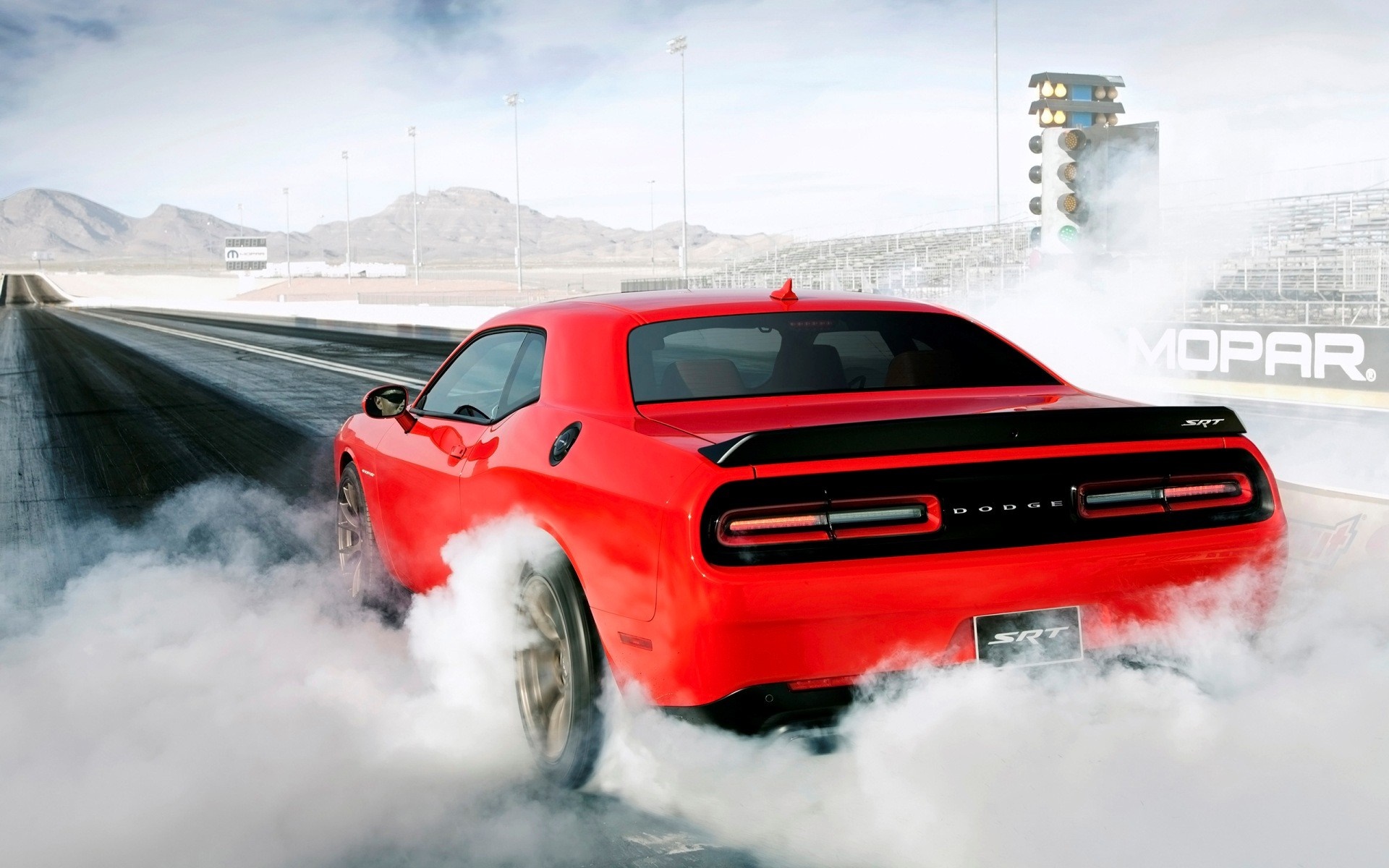 Red Dodge Challenger SRT doing a burnout on a drag strip HD Wallpaper