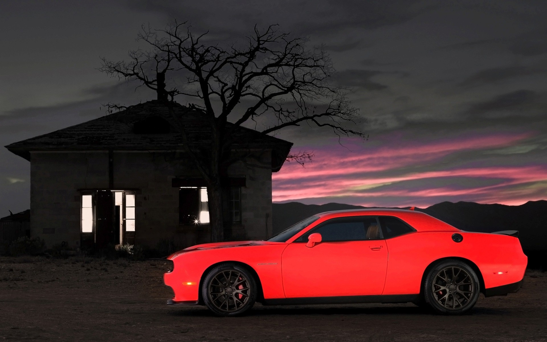 Red Dodge Challenger parked by an abandoned house at dusk HD Wallpaper