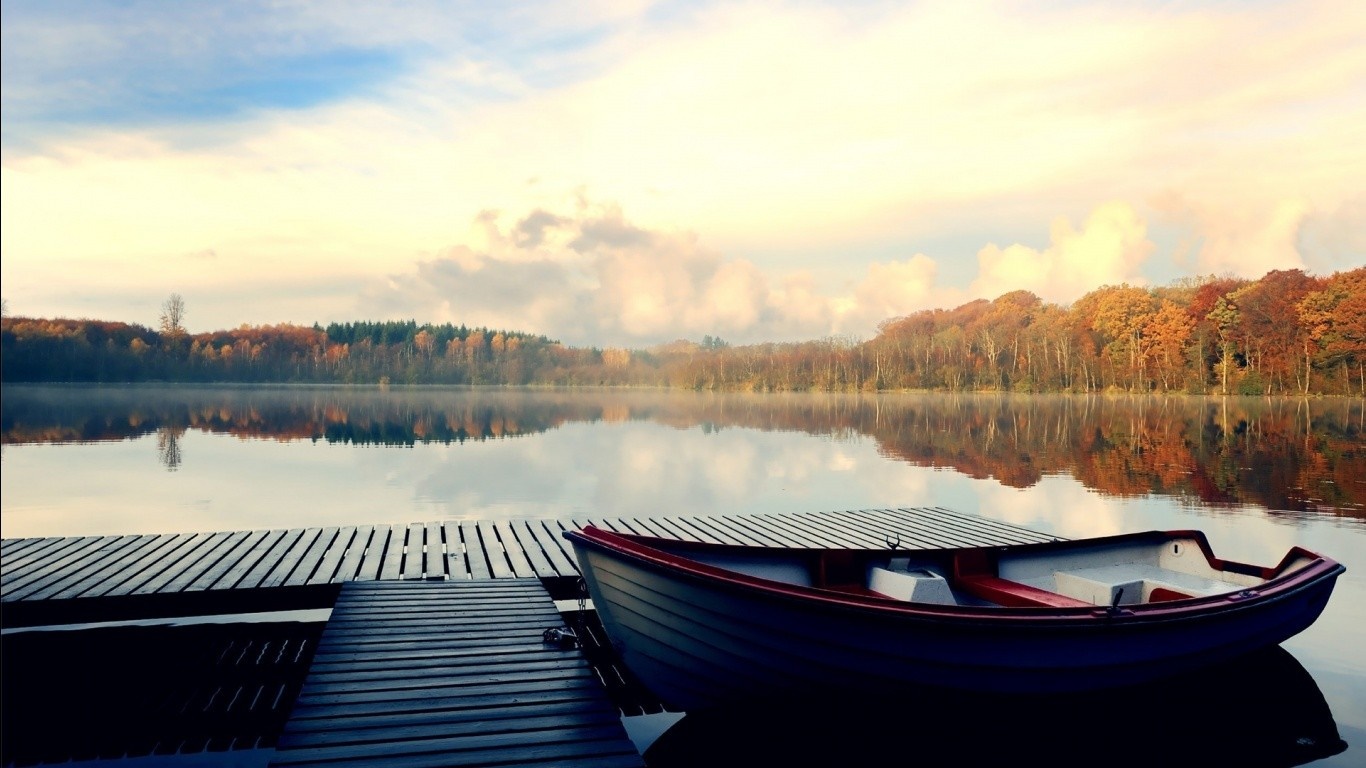 Boat docked on a wooden pier at a lake during autumn HD Wallpaper