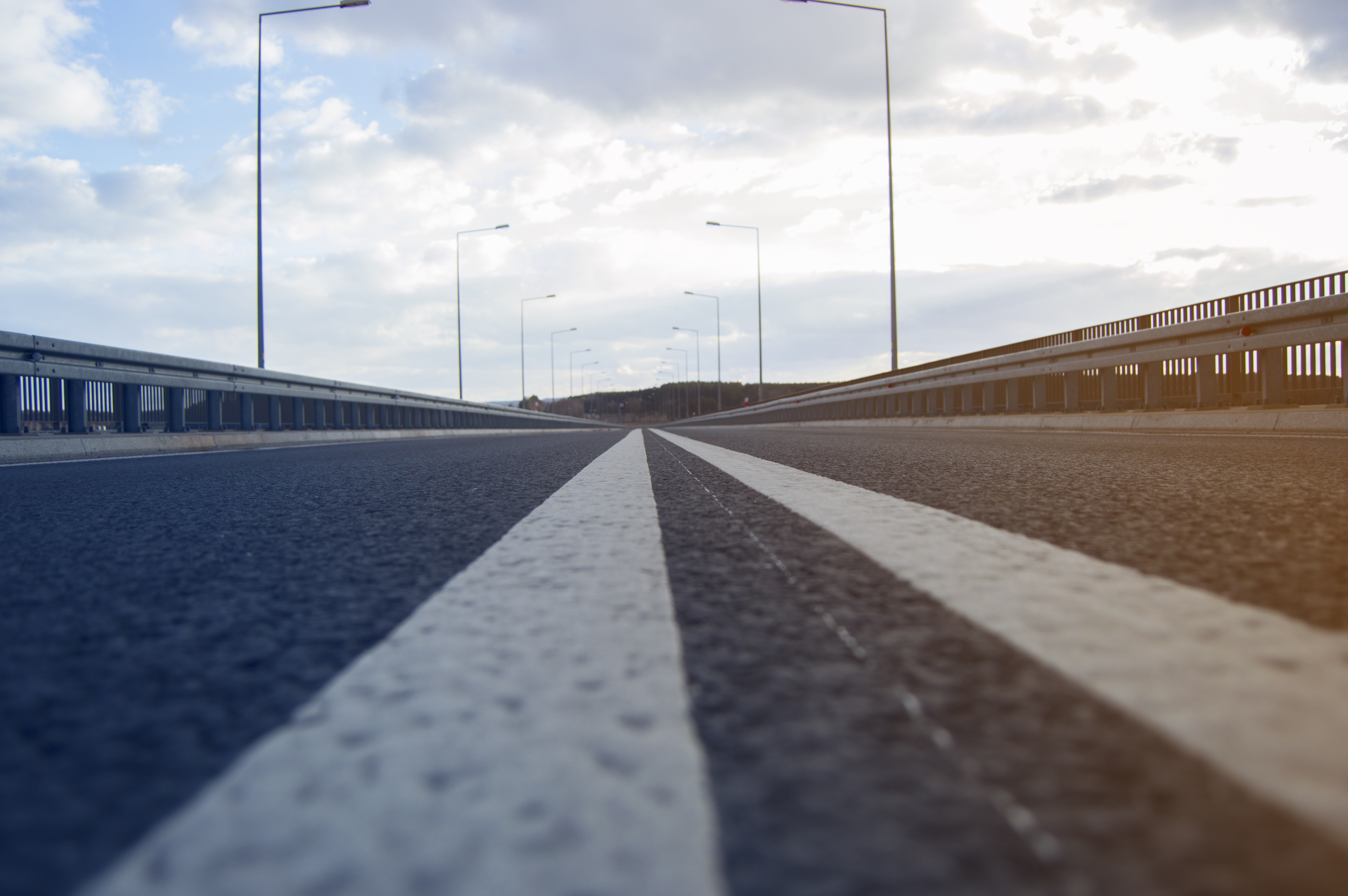 Road with double white lines and streetlights HD Wallpaper
