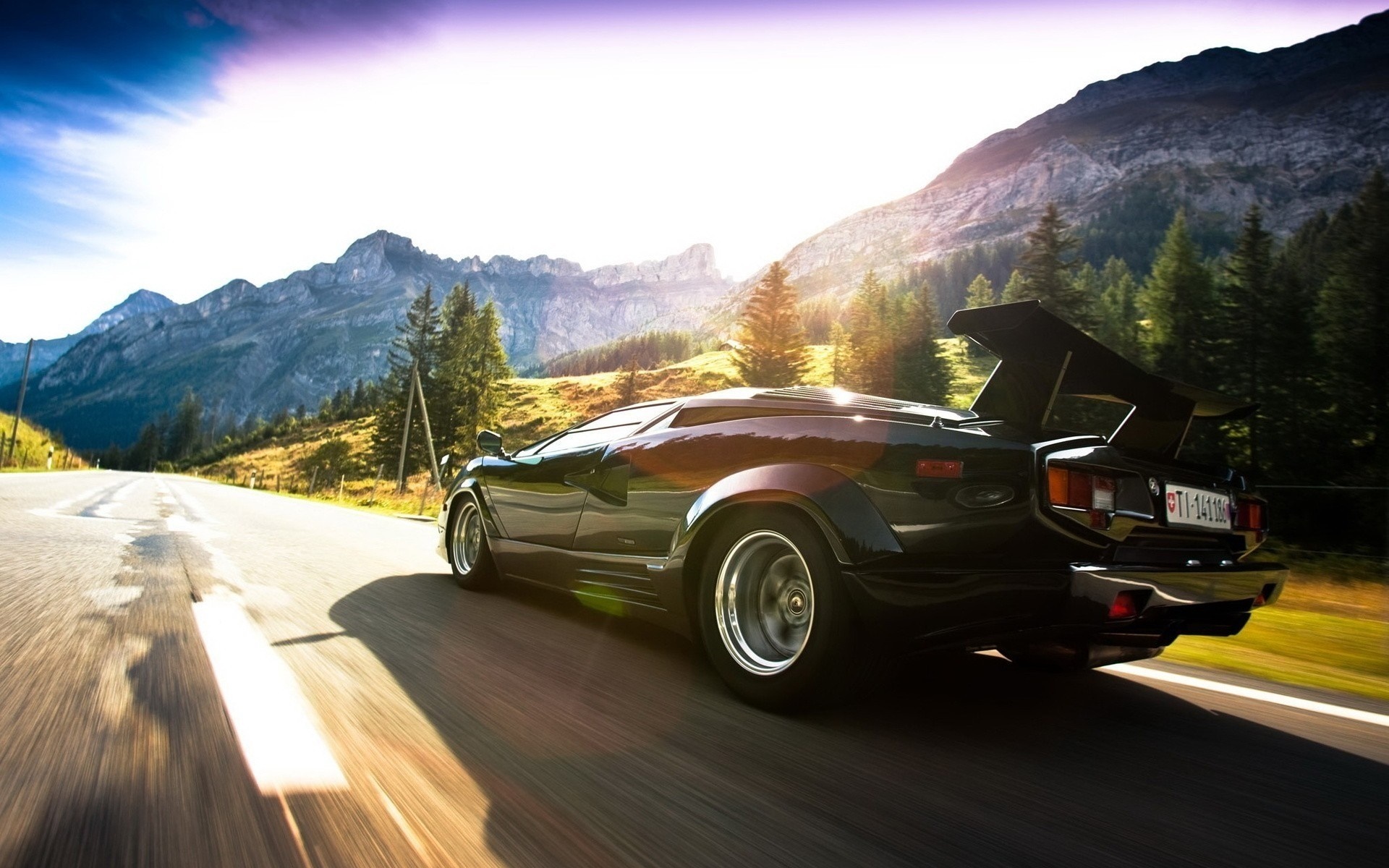 Black Lamborghini Countach driving on a mountain road HD Wallpaper