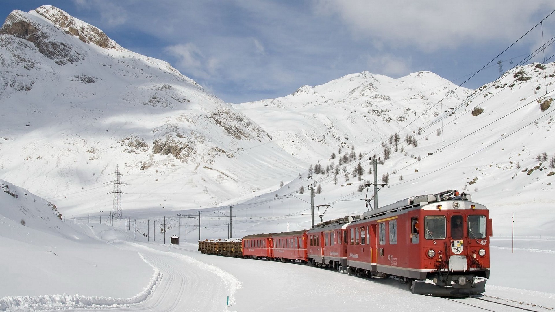 Red train in snowy Swiss Alps landscape HD Wallpaper