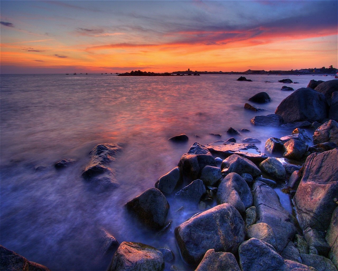 Sunset over rocky shore with calm sea HD Wallpaper