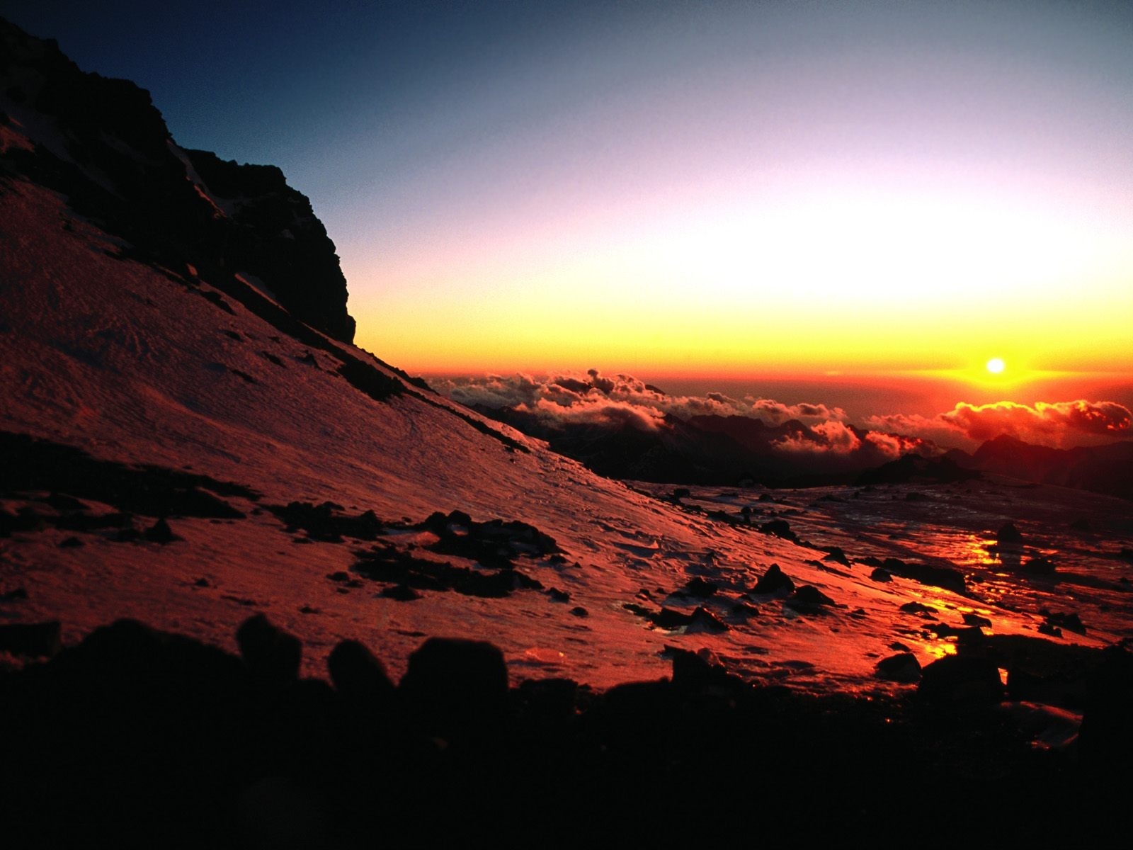 Sunrise over clouds on a snowy mountain HD Wallpaper