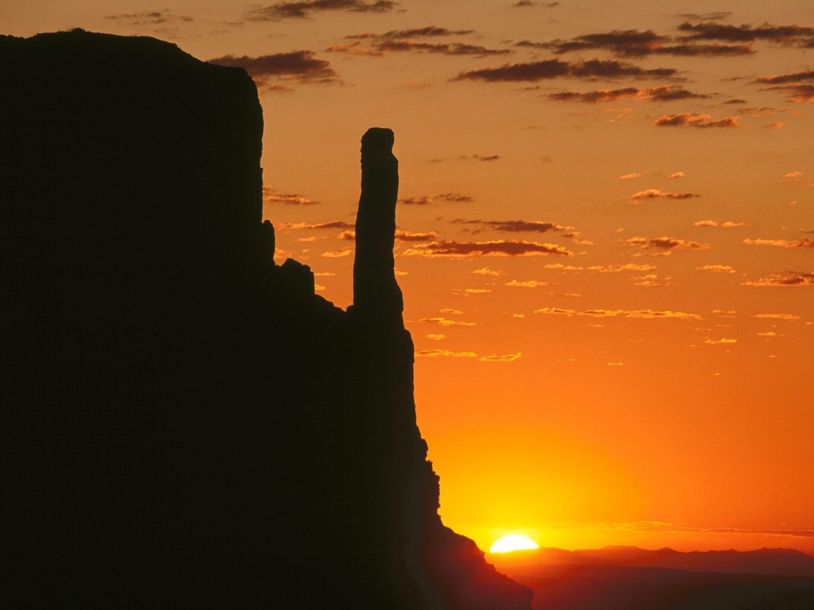 Silhouette of rock formations against a sunset sky HD Wallpaper