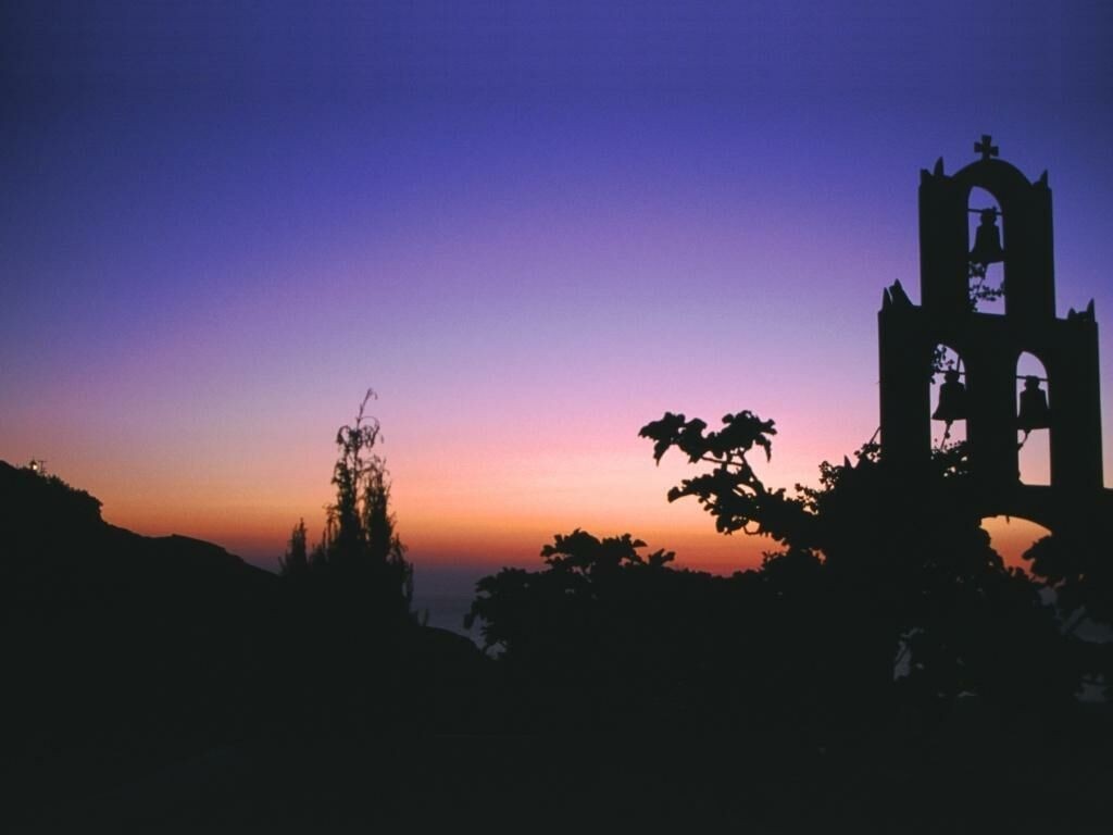 Silhouette of a bell tower against a sunset sky HD Wallpaper