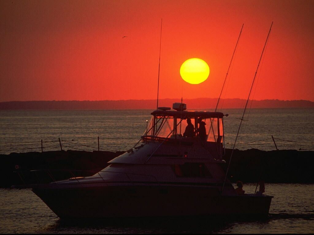 Boat sailing at sunset over the ocean HD Wallpaper