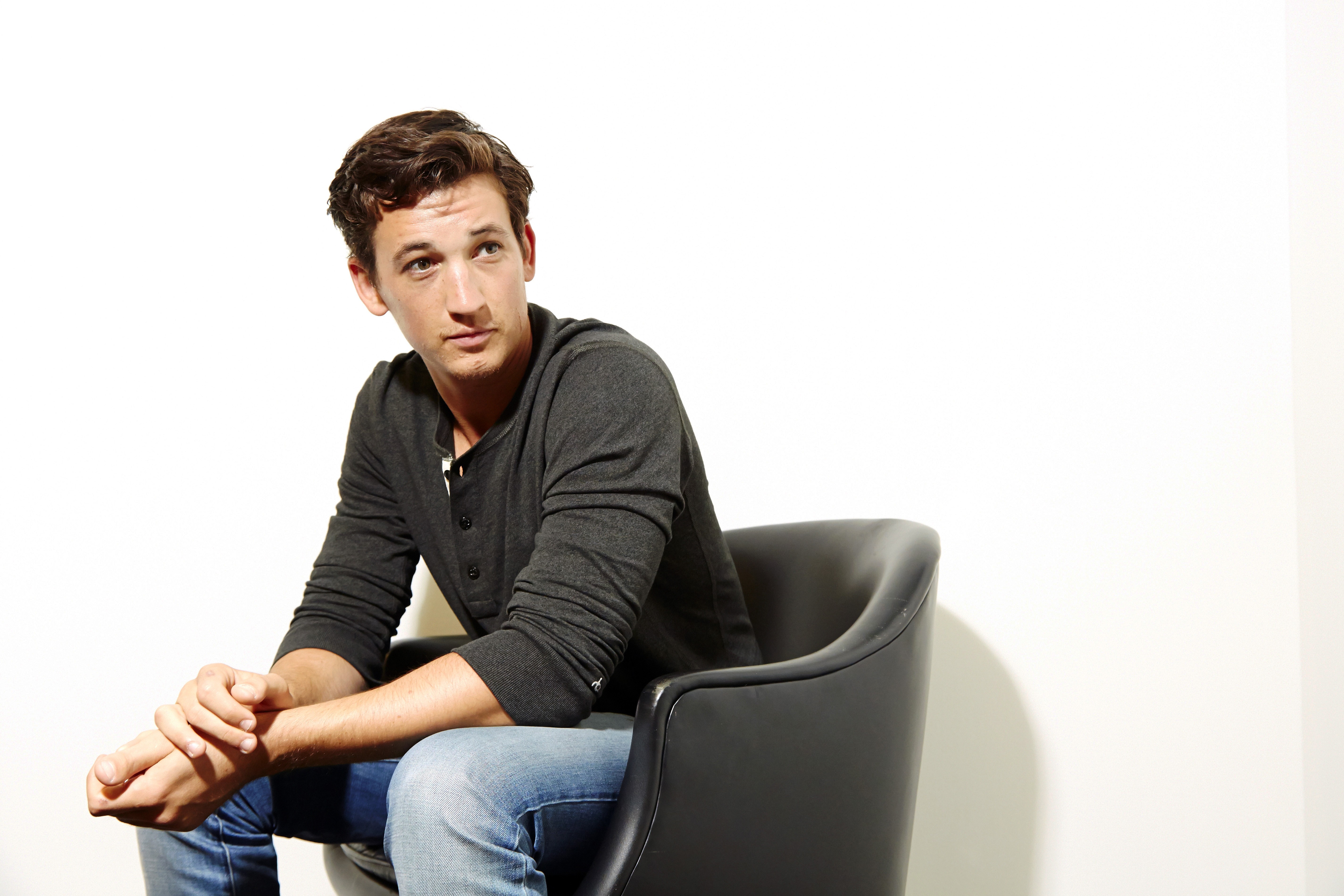 Miles Teller sitting in a chair HD Wallpaper