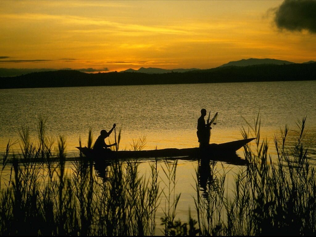 Two people in a canoe at sunset on a lake HD Wallpaper
