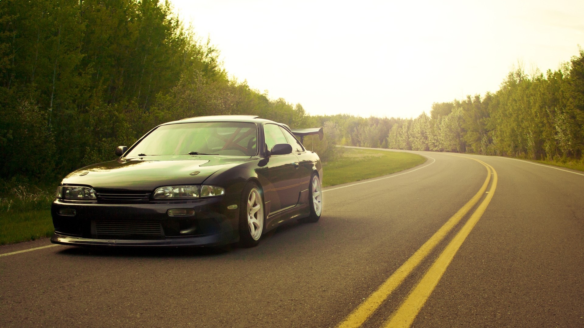 Dark sports car on a winding road HD Wallpaper