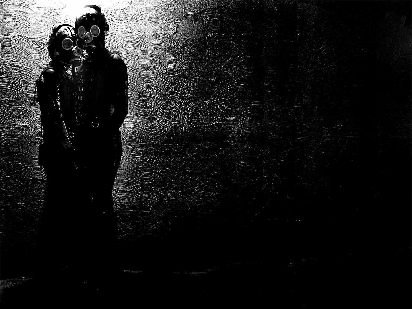 Two figures in gas masks against a textured wall HD Wallpaper