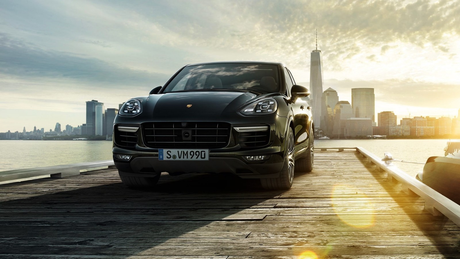 Black Porsche Cayenne on a wooden pier with city skyline HD Wallpaper