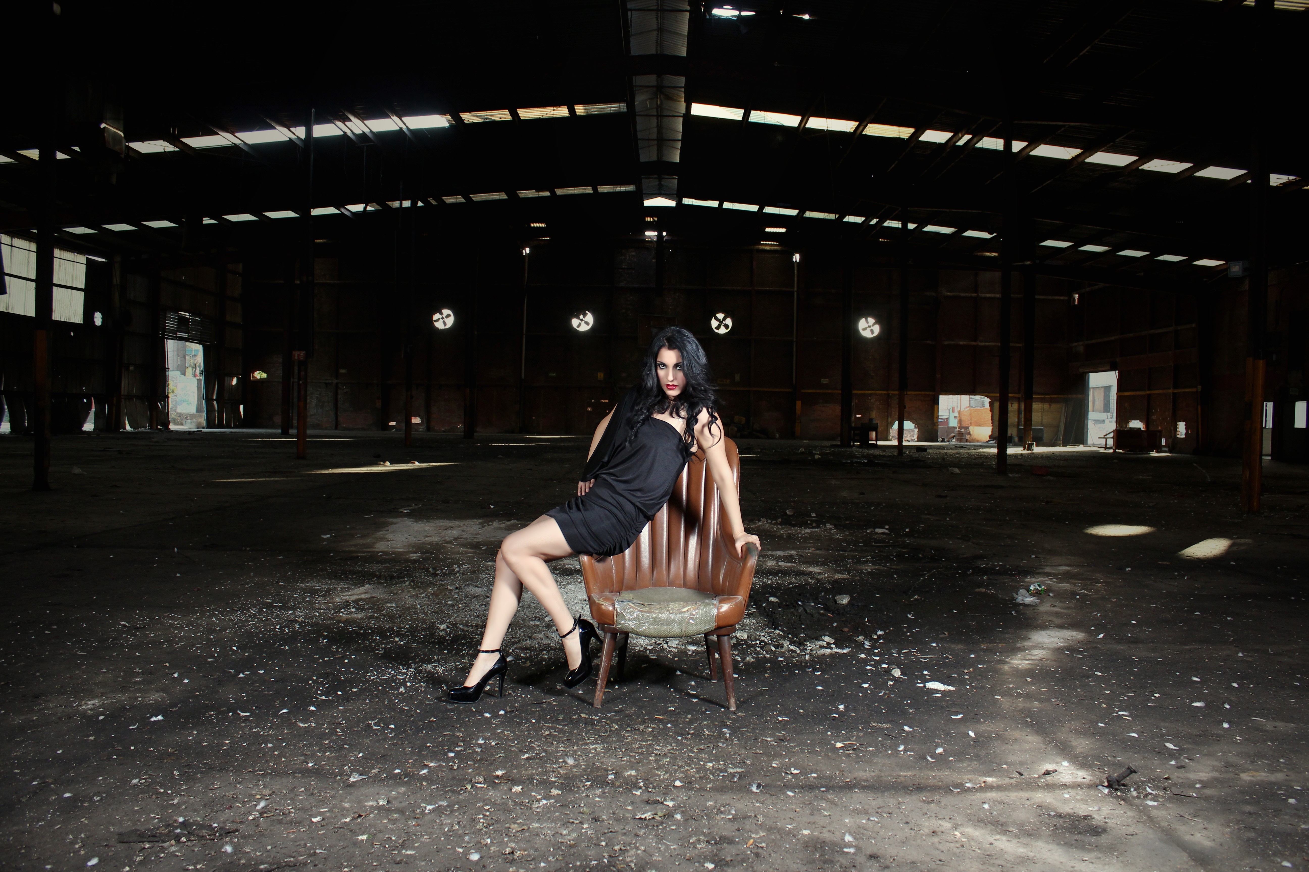 Woman in black dress sitting in an abandoned warehouse HD Wallpaper