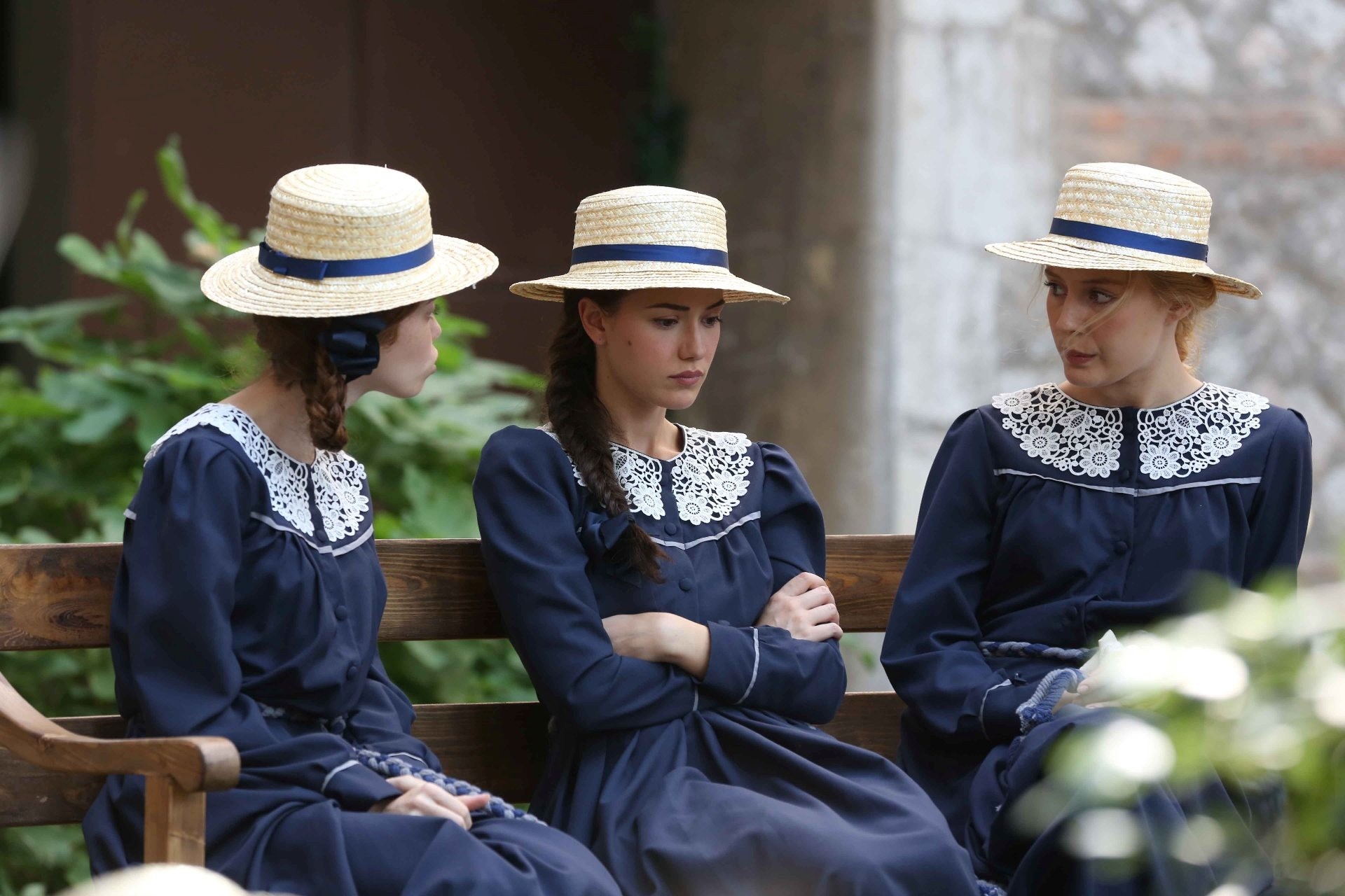 Three women in school uniforms and hats sitting on a bench HD Wallpaper