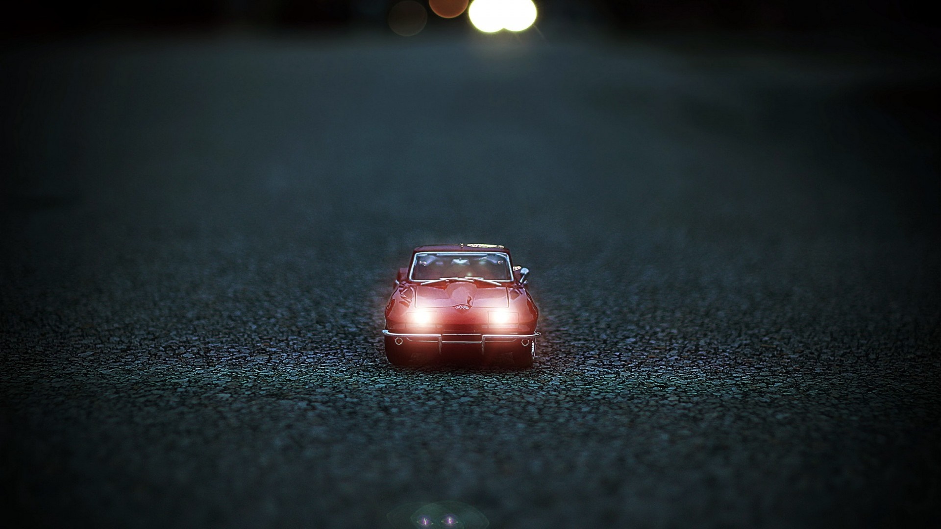 Red Corvette toy car at night with headlights on HD Wallpaper