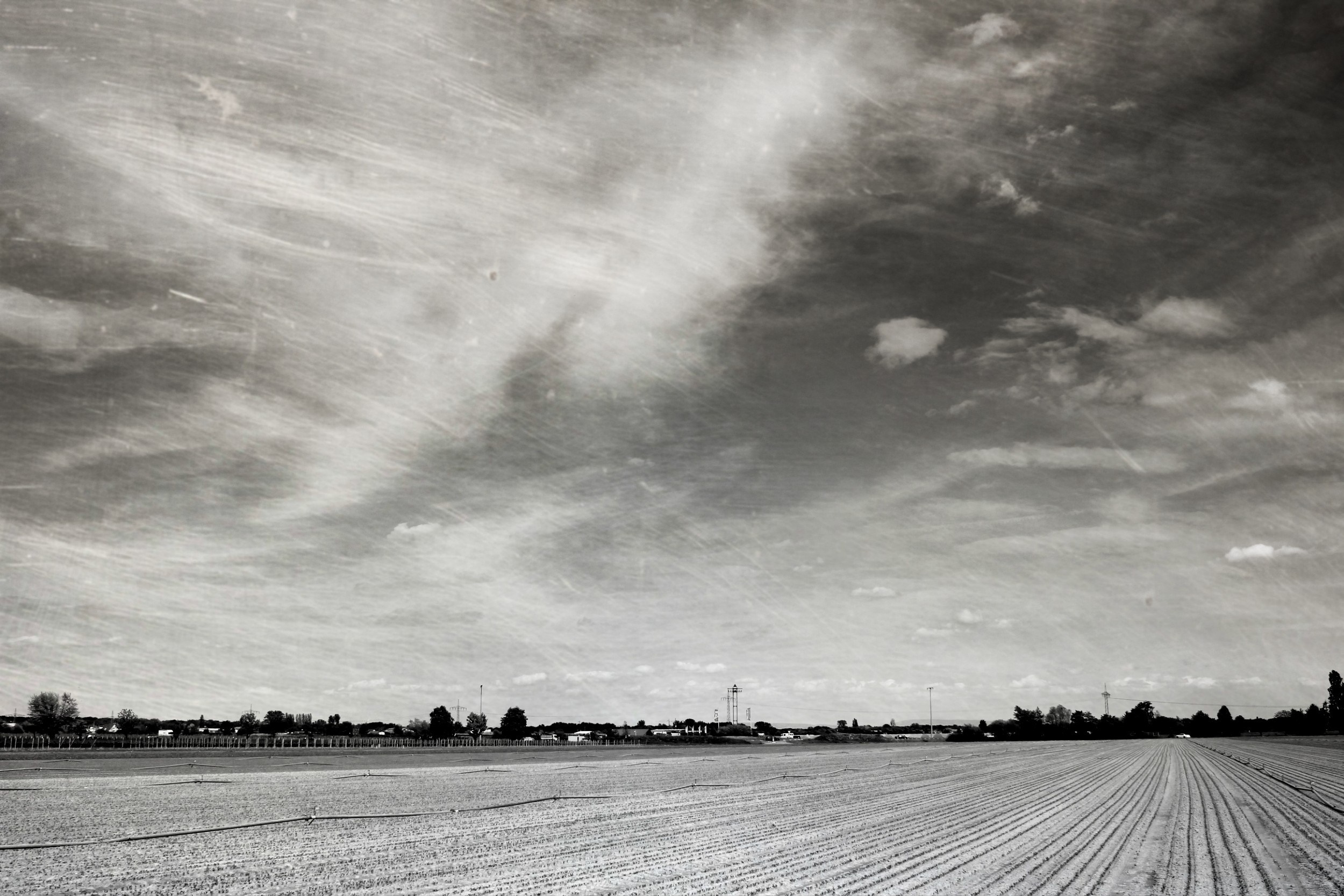 Tilled field under a cloudy sky HD Wallpaper
