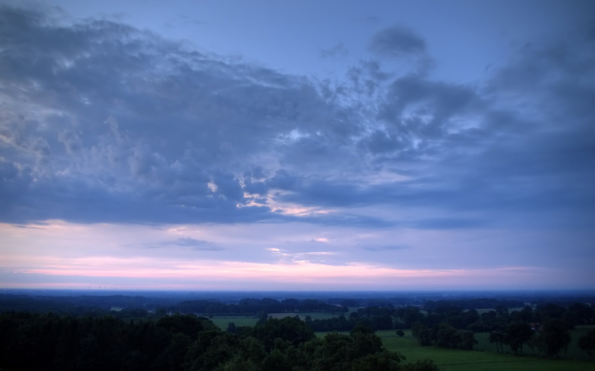 Dark clouds over a twilight landscape HD Wallpaper