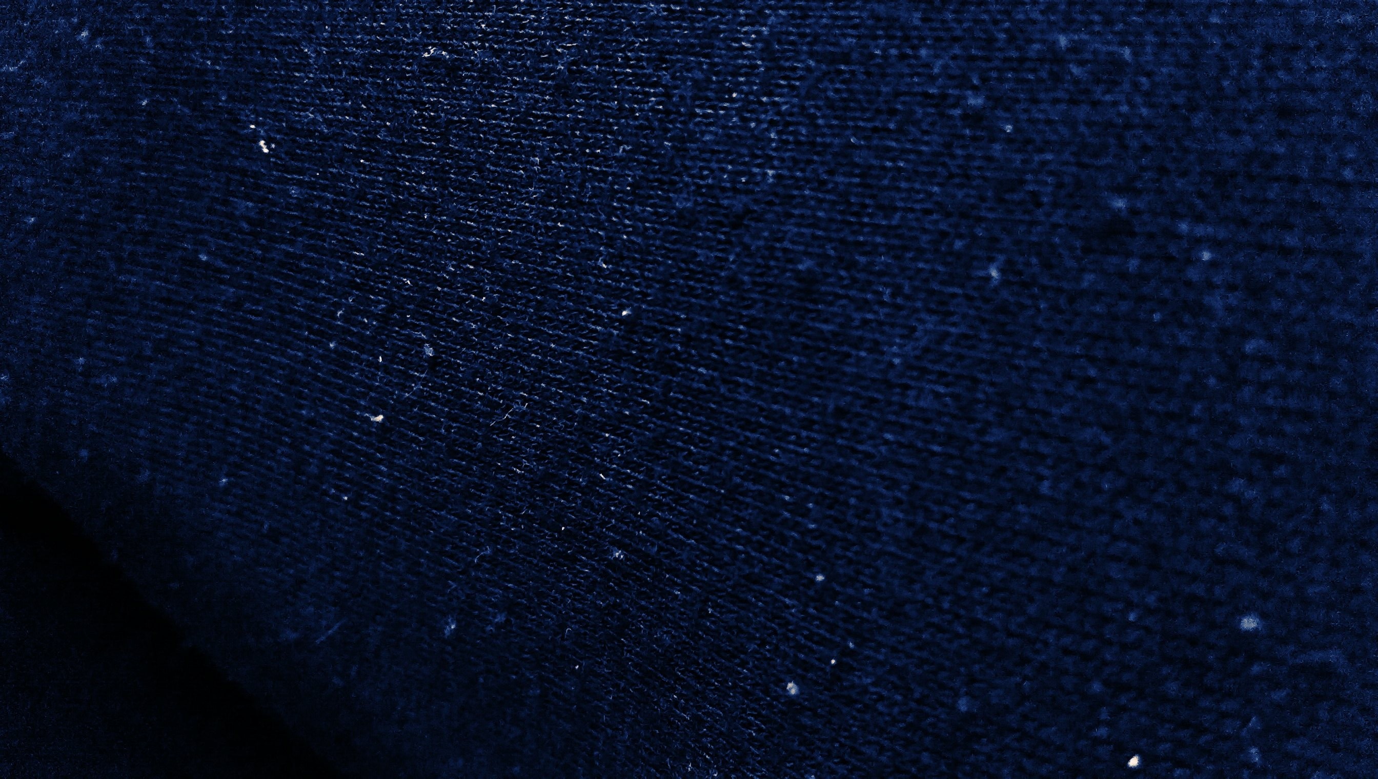 Close-up of dark blue fabric texture with small white specks HD Wallpaper