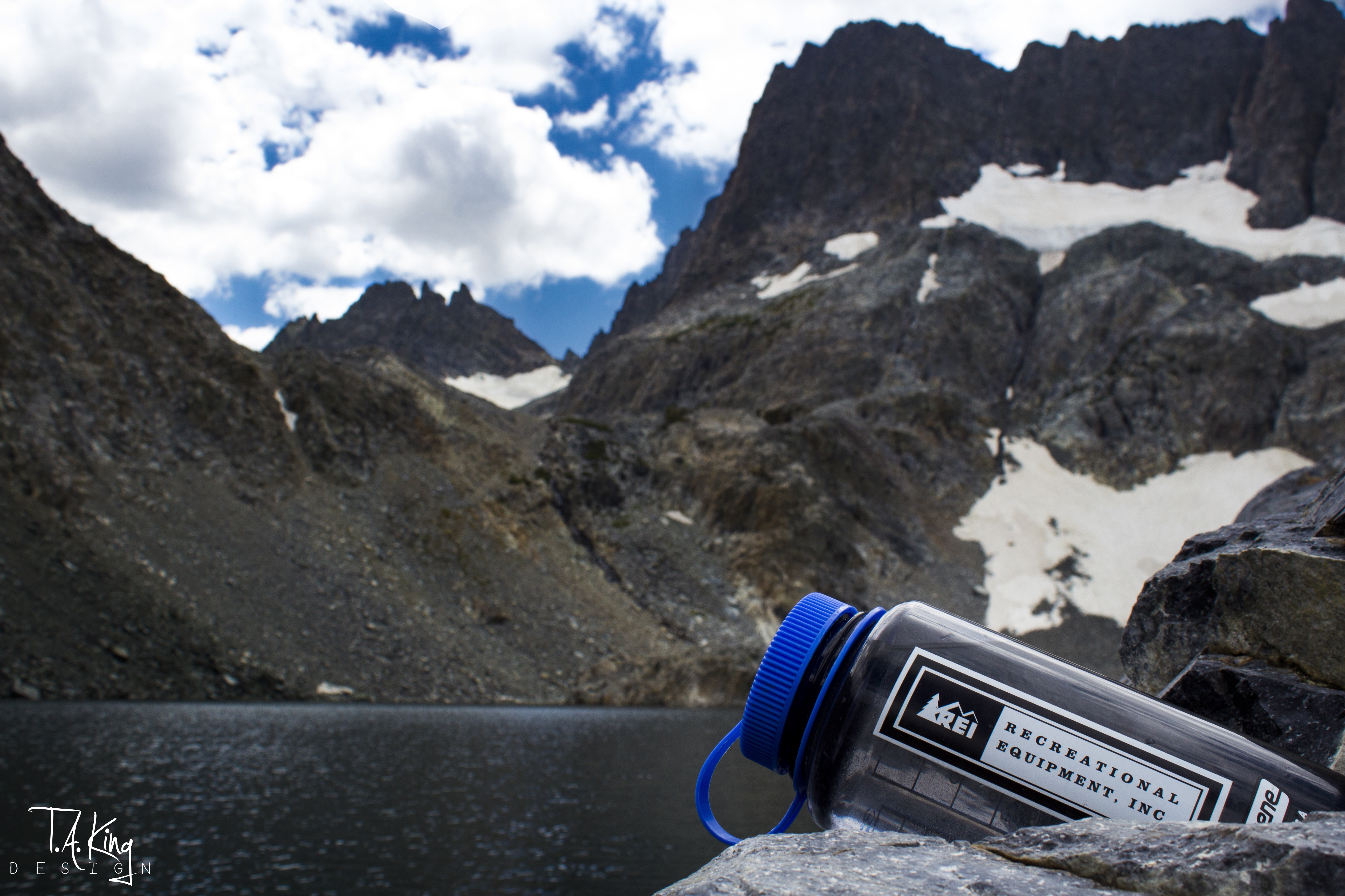 REI water bottle in front of mountain lake and peaks HD Wallpaper