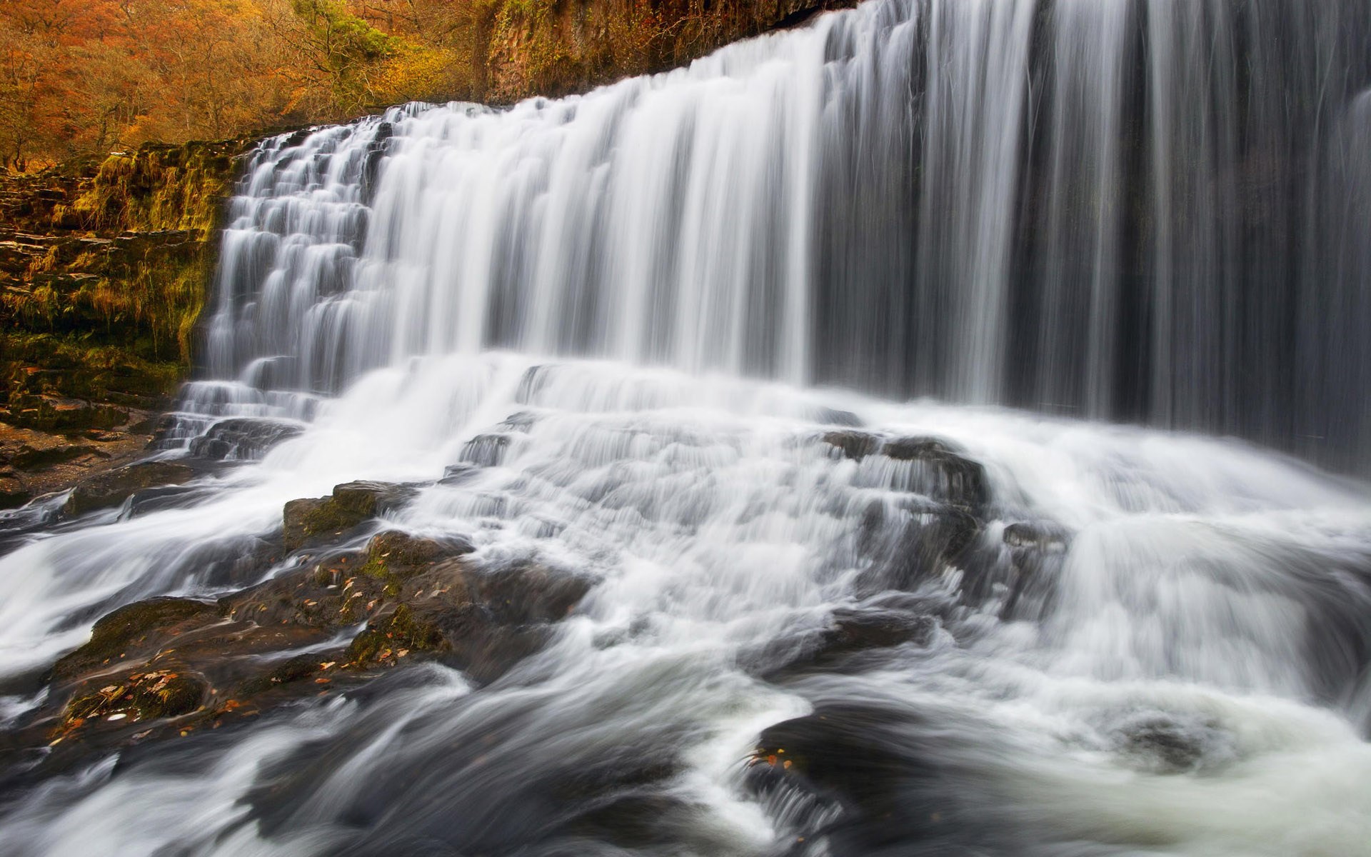 Waterfall cascading over rocks in autumn HD Wallpaper