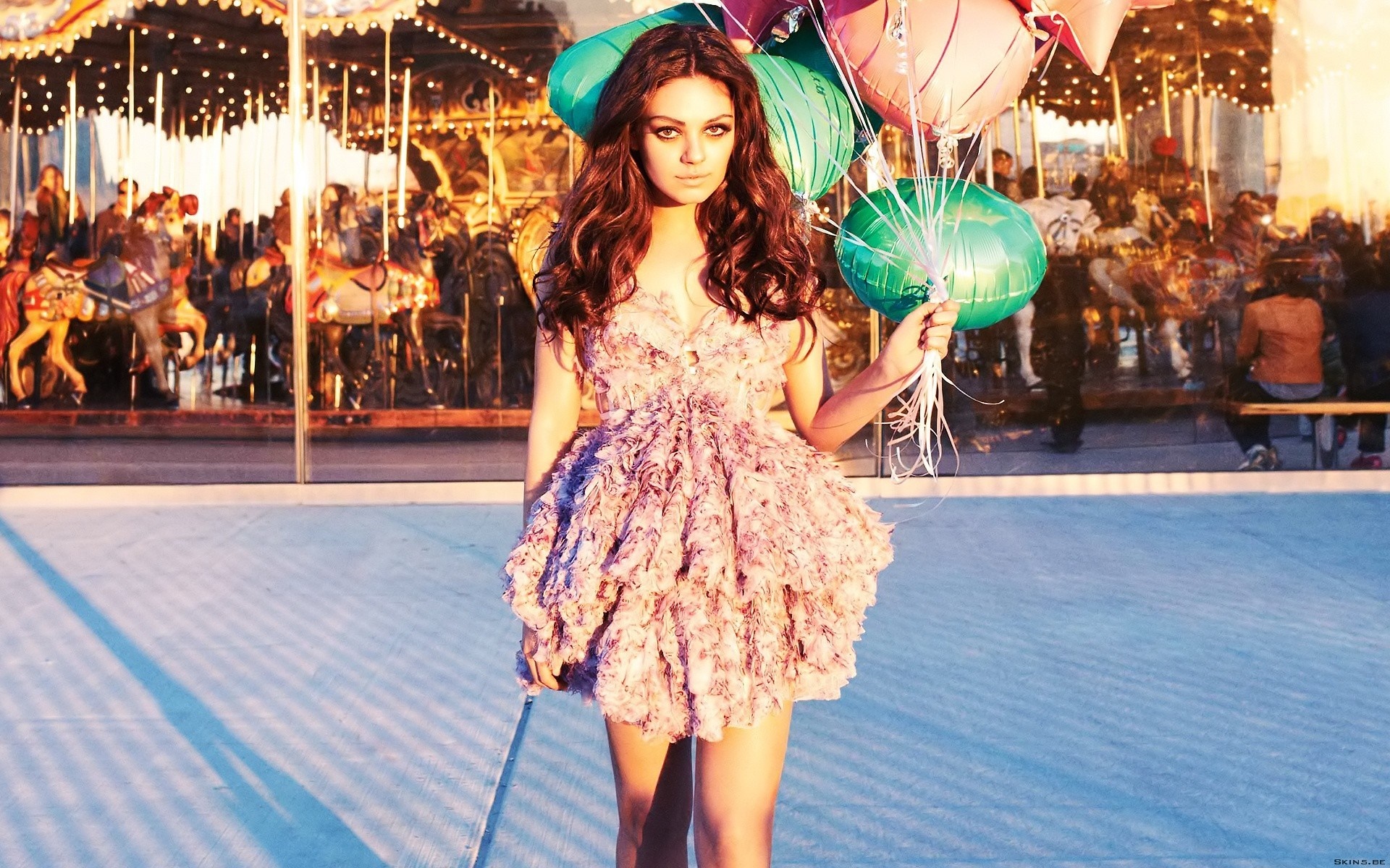 Mila Kunis with balloons in front of a carousel HD Wallpaper