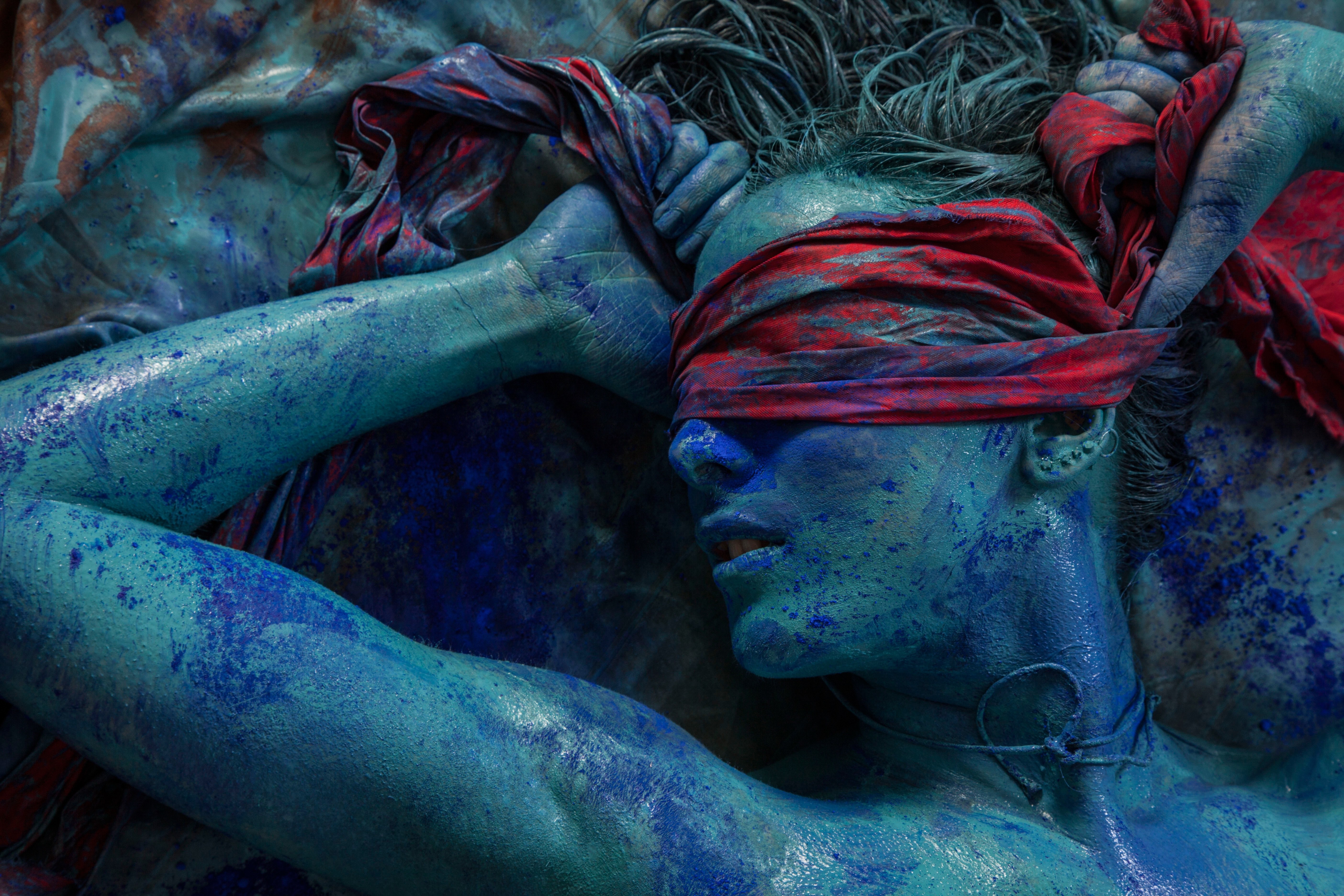 Woman covered in blue body paint with red blindfold HD Wallpaper