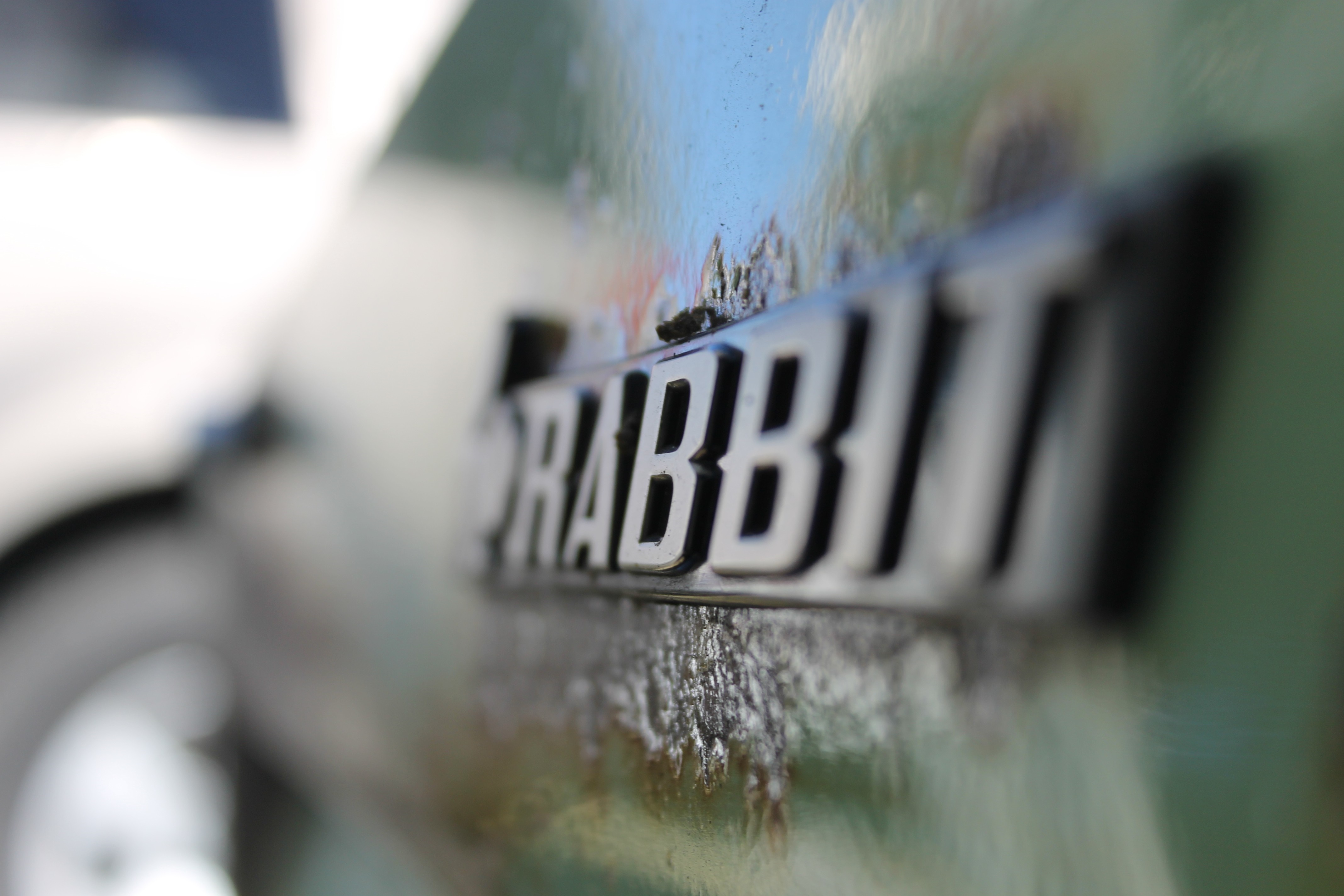 Close up of a car emblem on a green surface HD Wallpaper