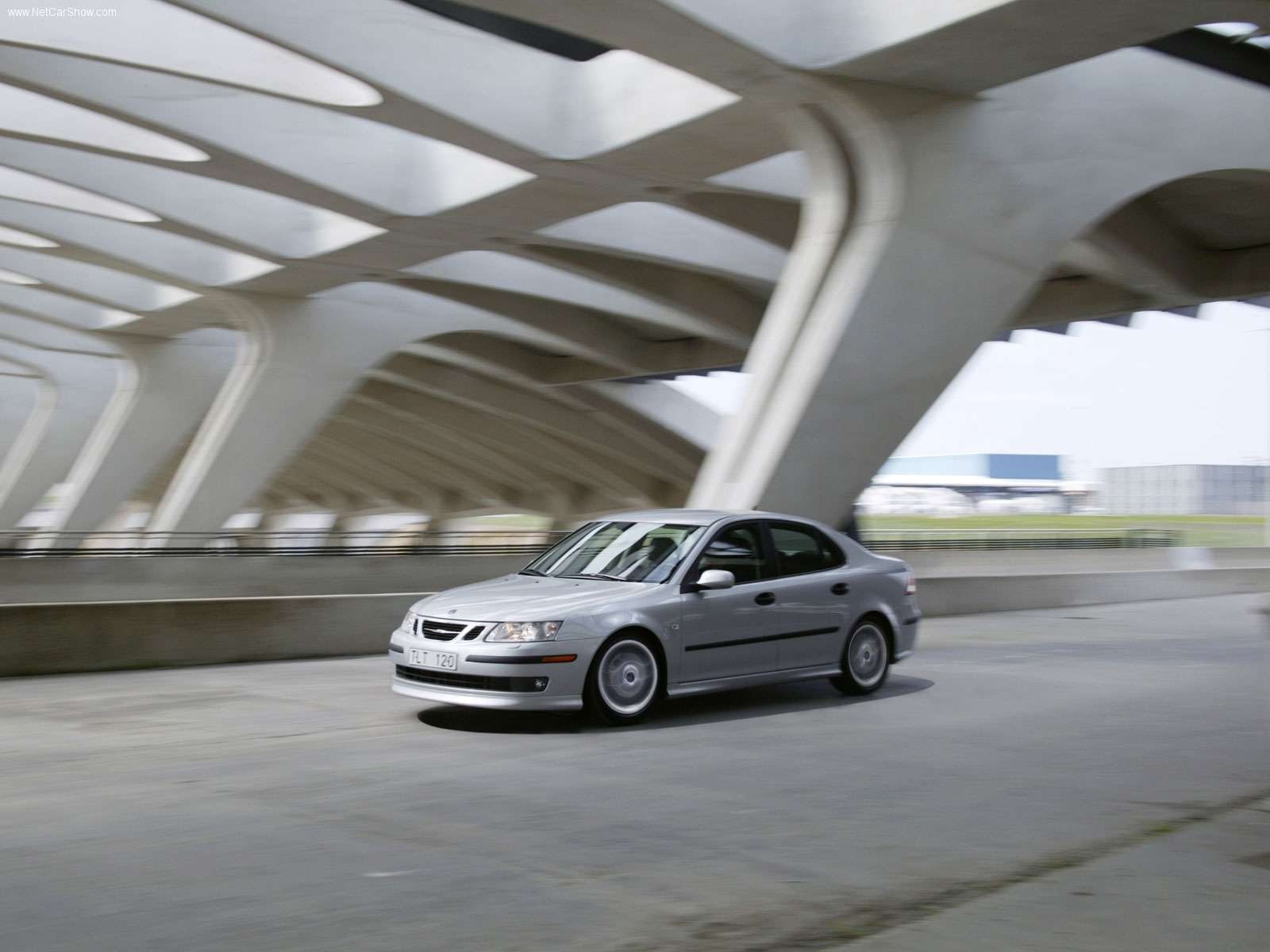 Silver Saab 9-3 driving under a modern bridge HD Wallpaper