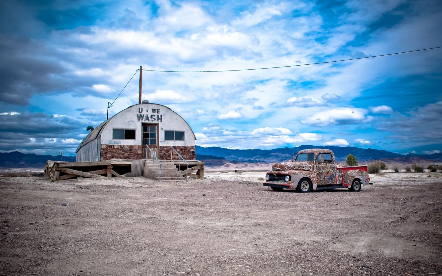 Abandoned car wash with rusty pickup truck in desert HD Wallpaper