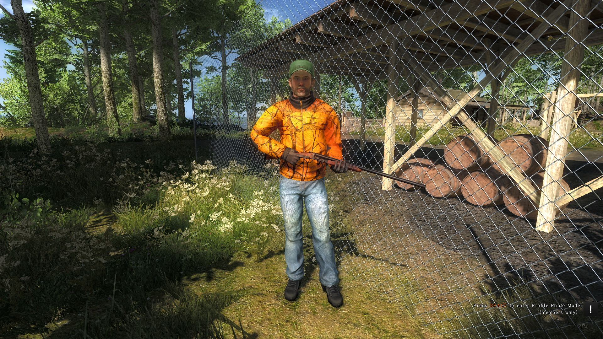 Man in orange jacket holding a rifle in a forest HD Wallpaper
