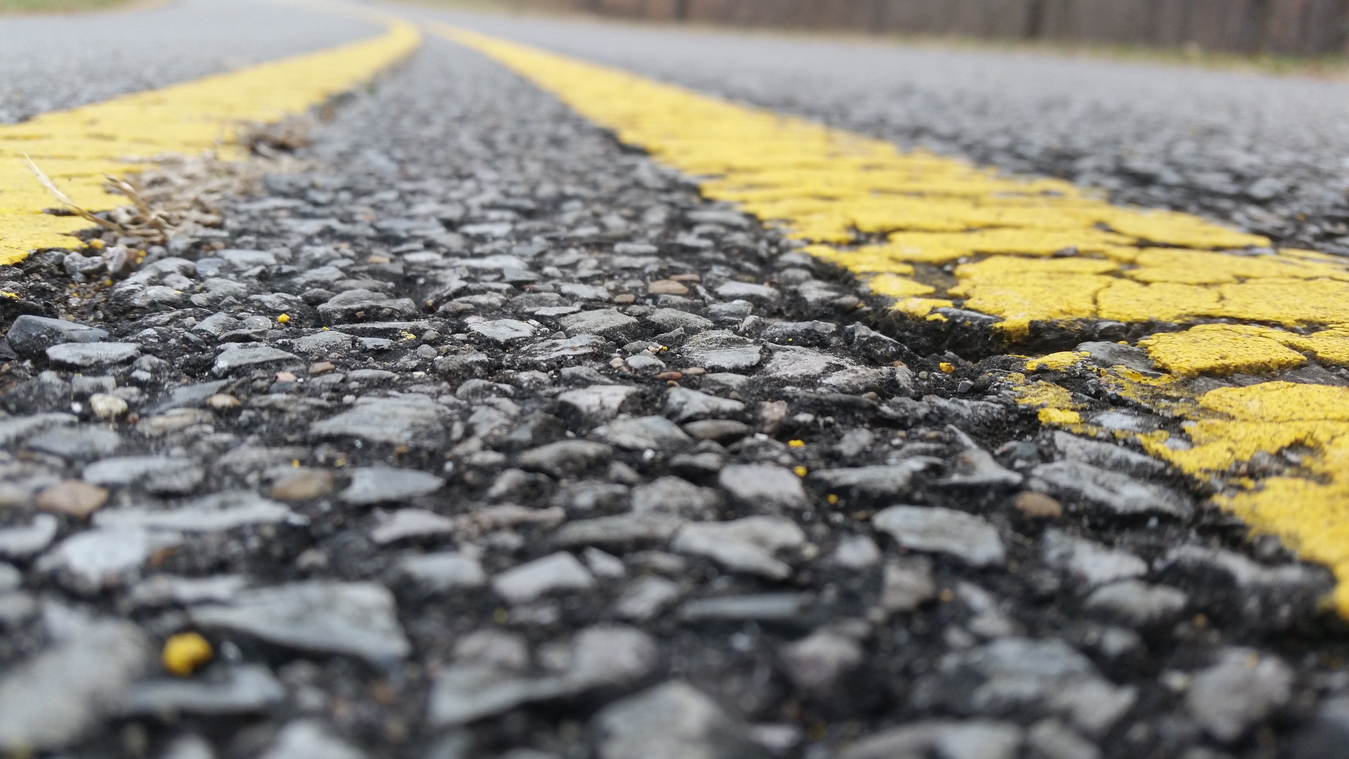 Close-up of asphalt road with yellow line HD Wallpaper