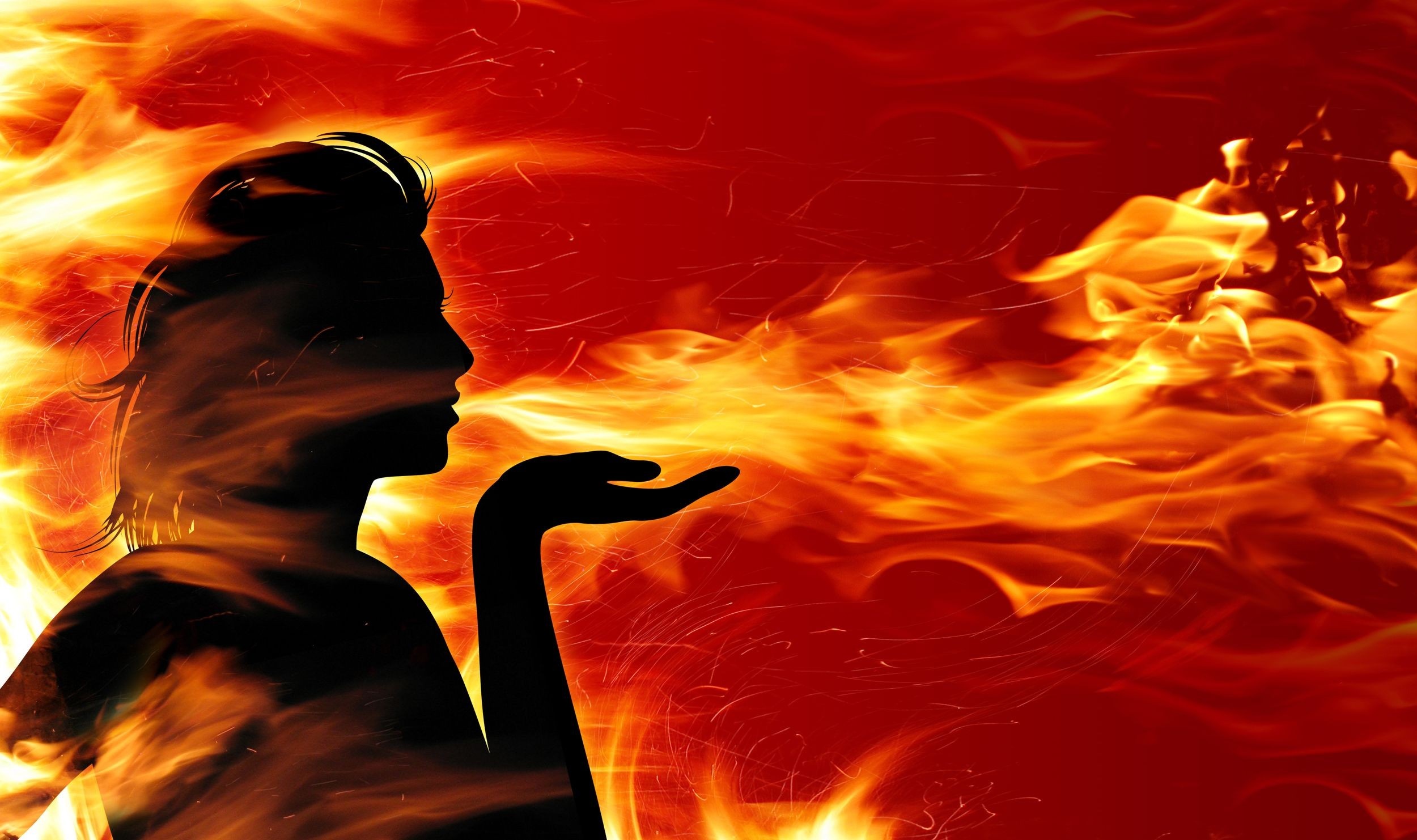 Silhouette of a woman blowing fire HD Wallpaper