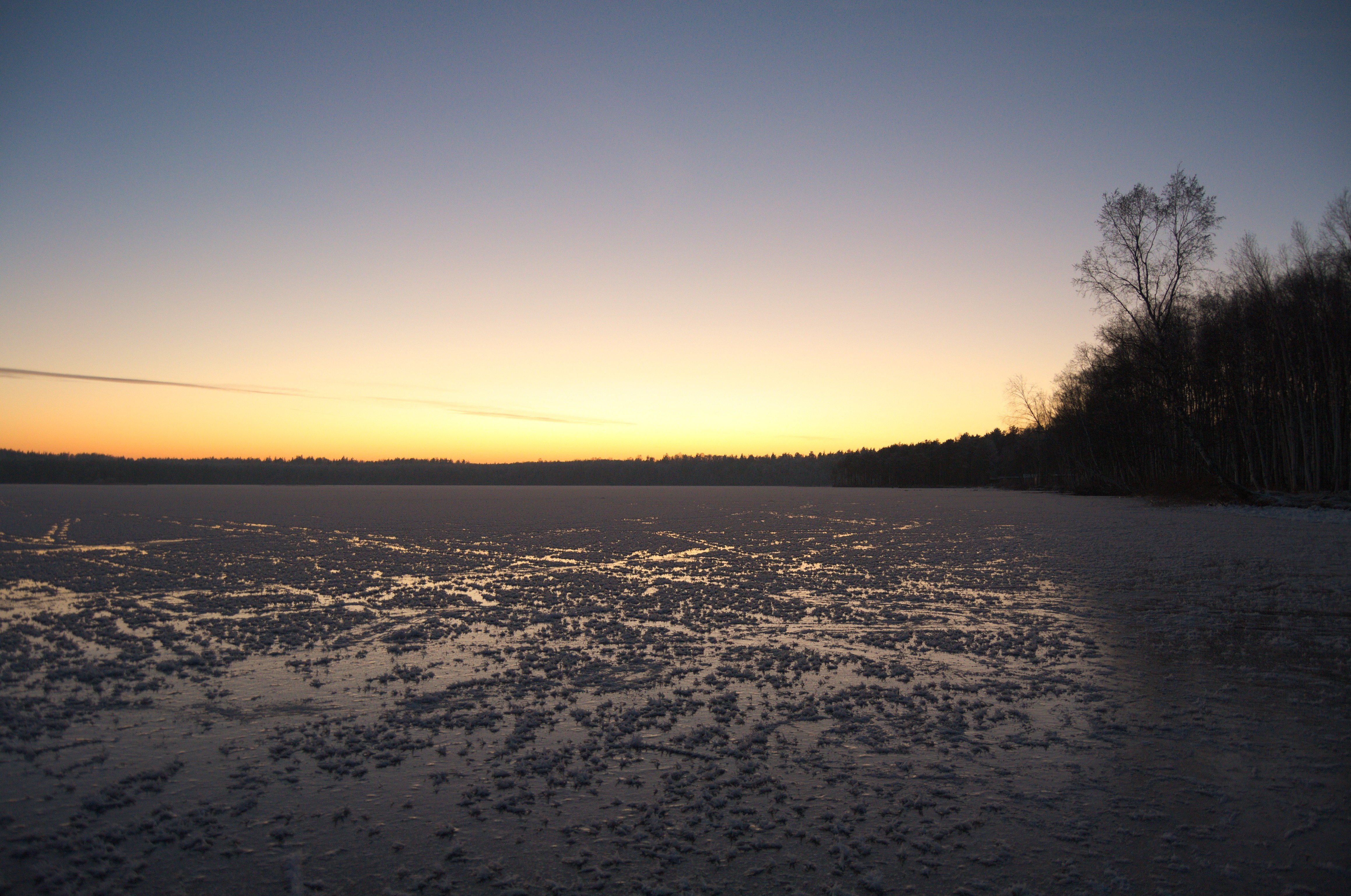 Frozen lake at sunset with forest horizon HD Wallpaper