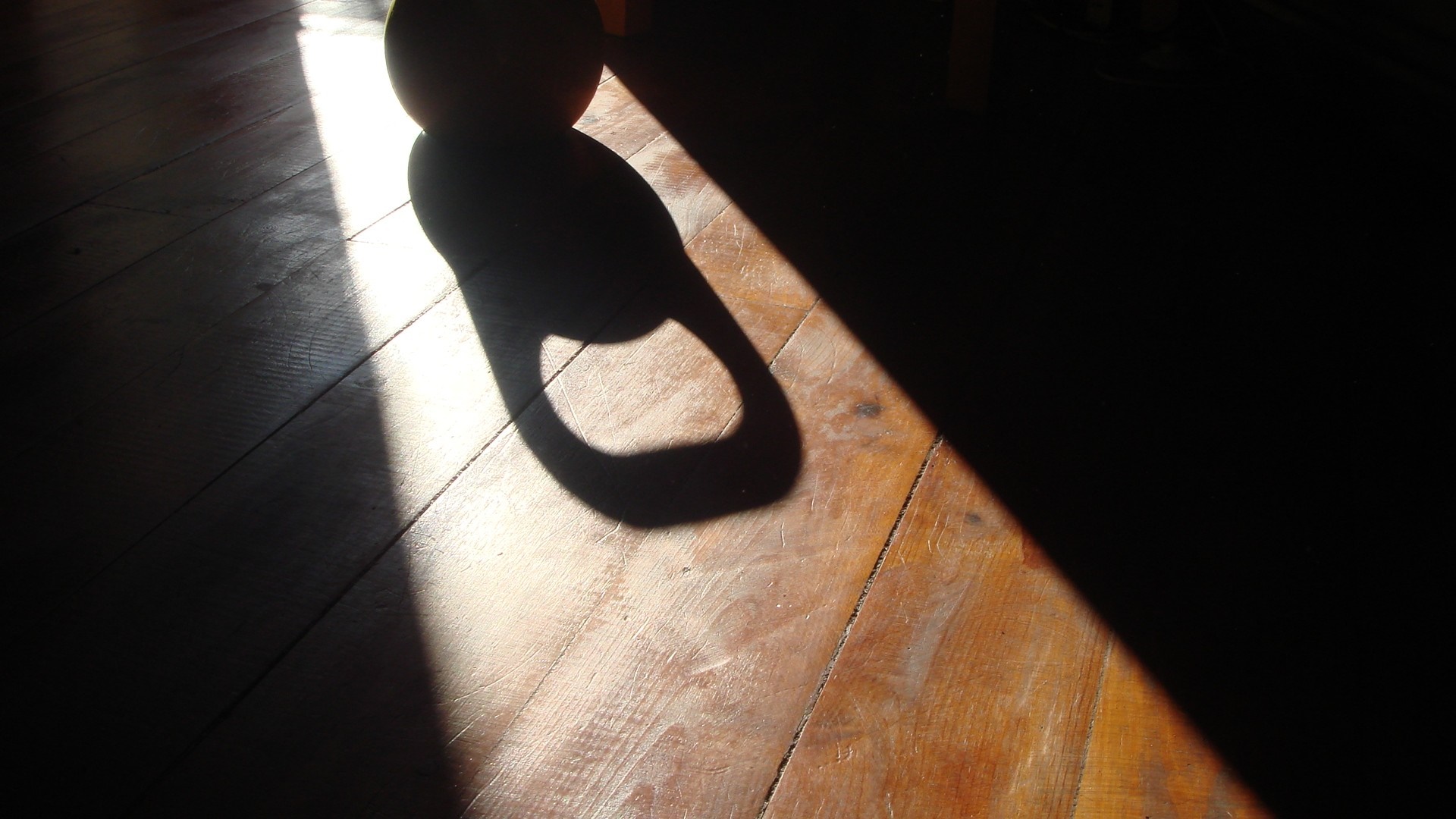 Shadow of a kettlebell on a wooden floor HD Wallpaper