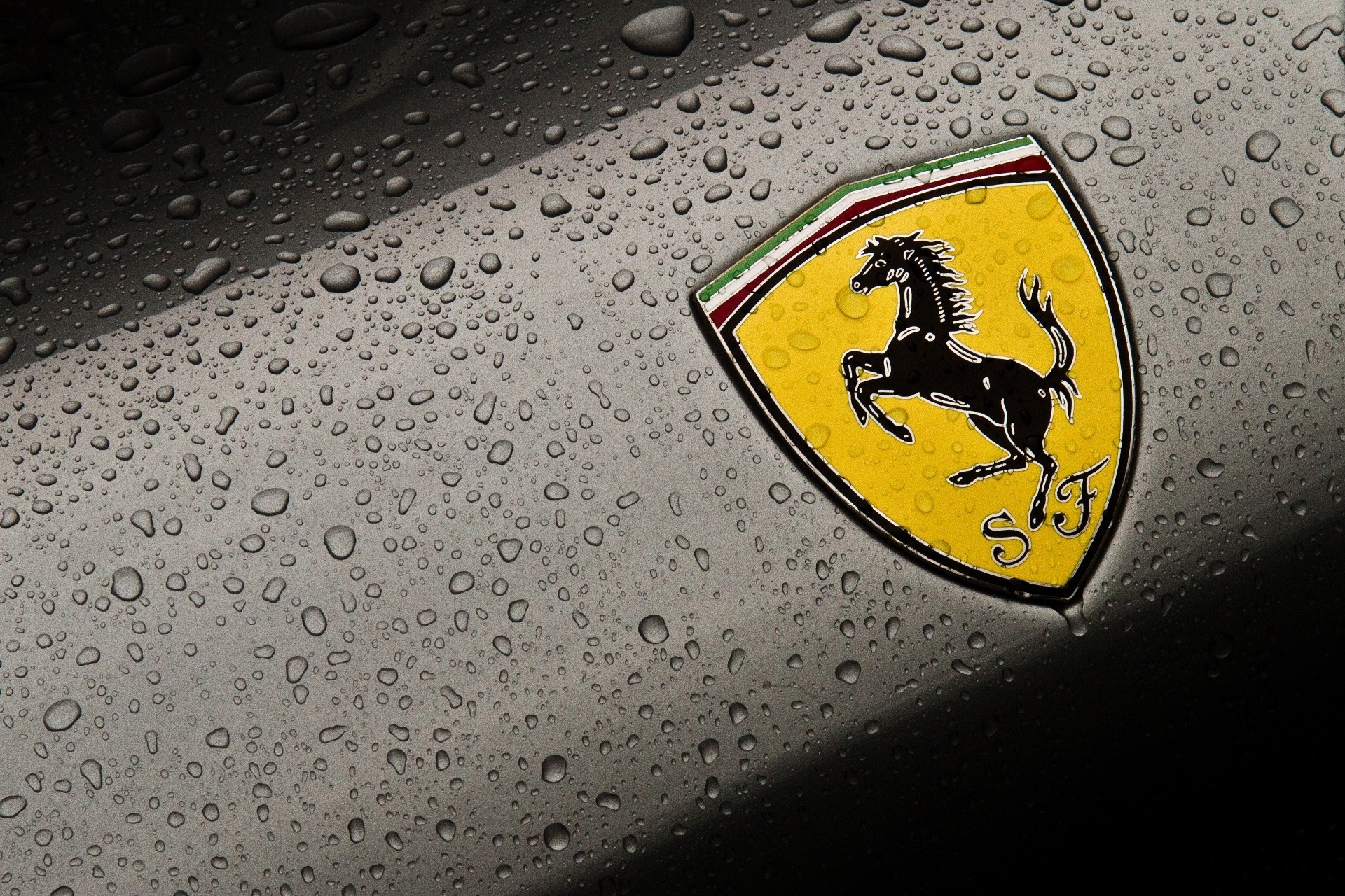 Ferrari logo on a wet car surface HD Wallpaper