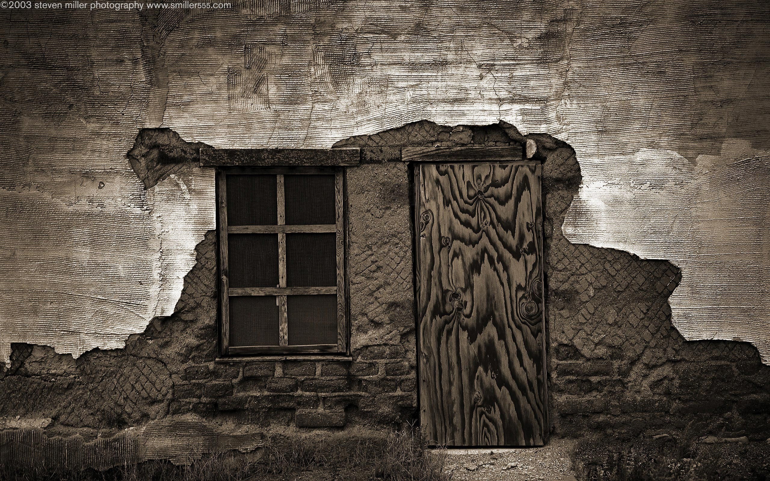 Monochrome photograph of a dilapidated wall with a window and door HD Wallpaper