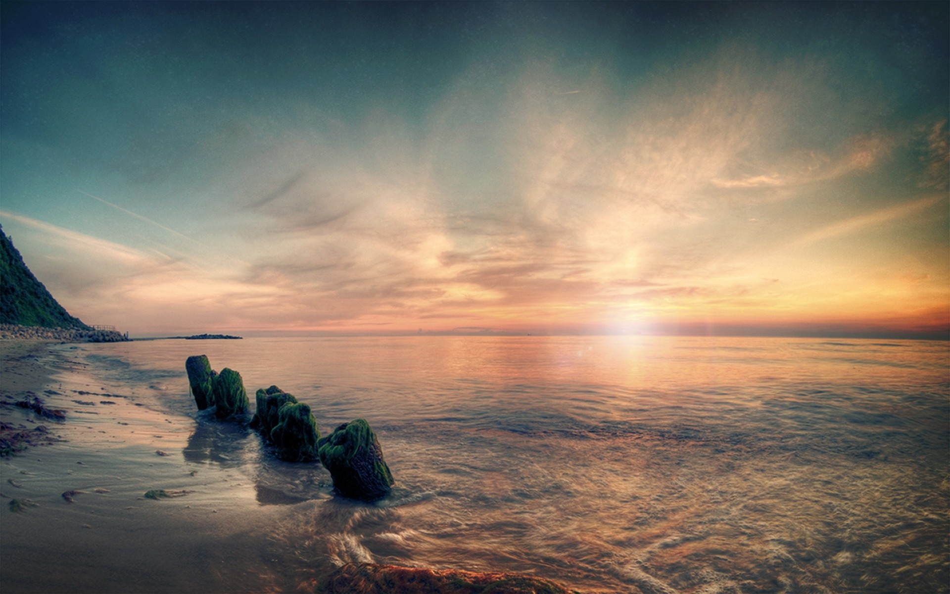 Sunset over the sea with wooden posts on the shore HD Wallpaper